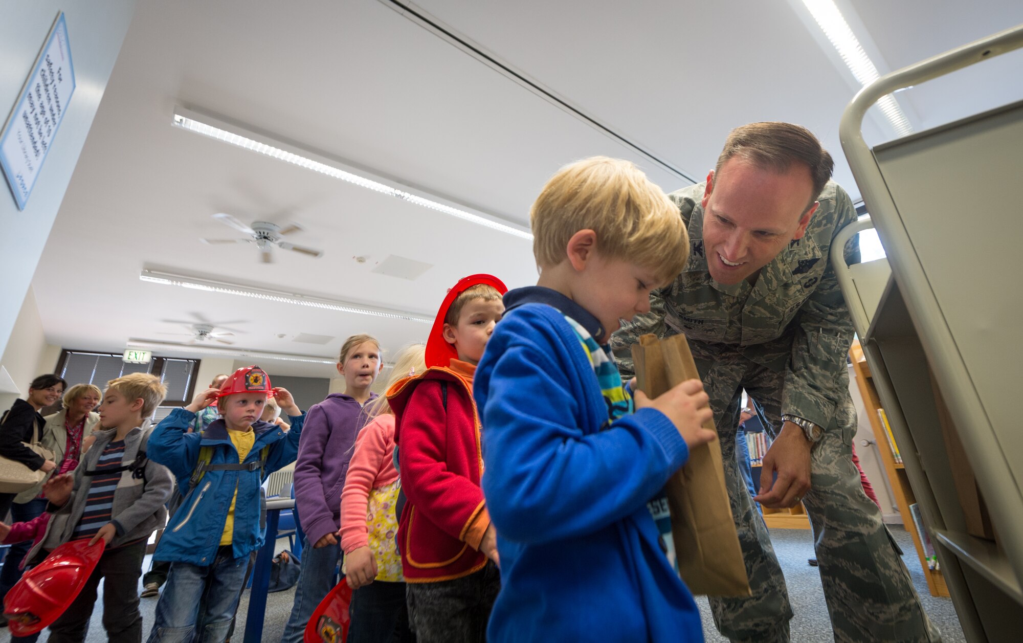 Col. Leslie Smith, 86th Airlift Wing vice commander, hands out goodie bags to a group of children from the Villa Winzig Kindergarten during a tour of Ramstein Air Base, Germany, Oct. 2, 2014. With more than 50,000 American citizens living in the greater Kaiserslautern area, U.S. Air Force units have shared a 60-year partnership with their host nation counterparts and since 2009 several groups of German kindergarten children have visited Ramstein to continue those relationships. (U.S. Air Force photo/Airman 1st Class Jordan Castelan)