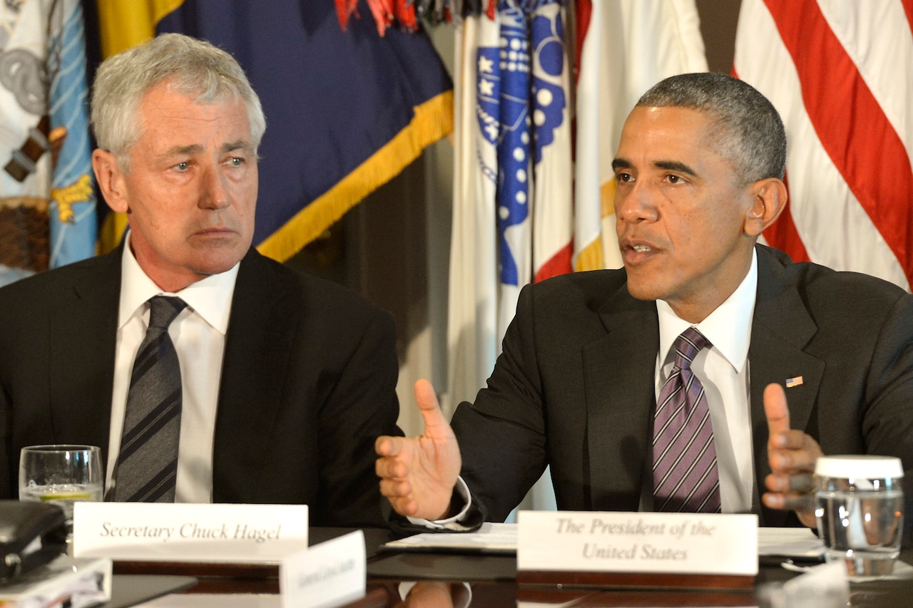 President Barack Obama, center, addresses the media after meeting with Defense Secretary Chuck Hagel, left, Army Gen. Martin E. Dempsey, not shown, chairman of the Joint Chiefs of Staff, and combatant commanders at the Pentagon, Oct. 8, 2014. DoD photo by Glenn Fawcett 