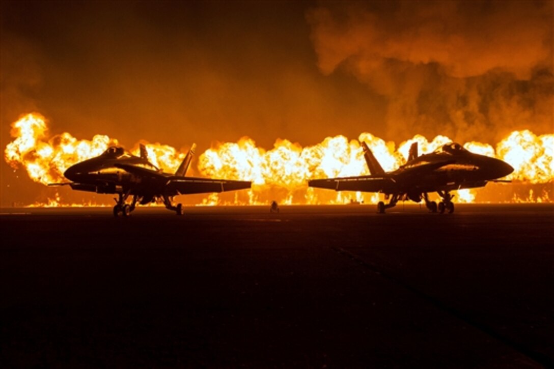 A wall of fire explodes behind the U.S. Navy Flight Demonstration Squadron, the Blue Angels, during the Marine Air Ground Task Force demonstration at the annual Miramar Air Show on Marine Corps Air Station Miramar, San Diego, Oct. 4, 2014.