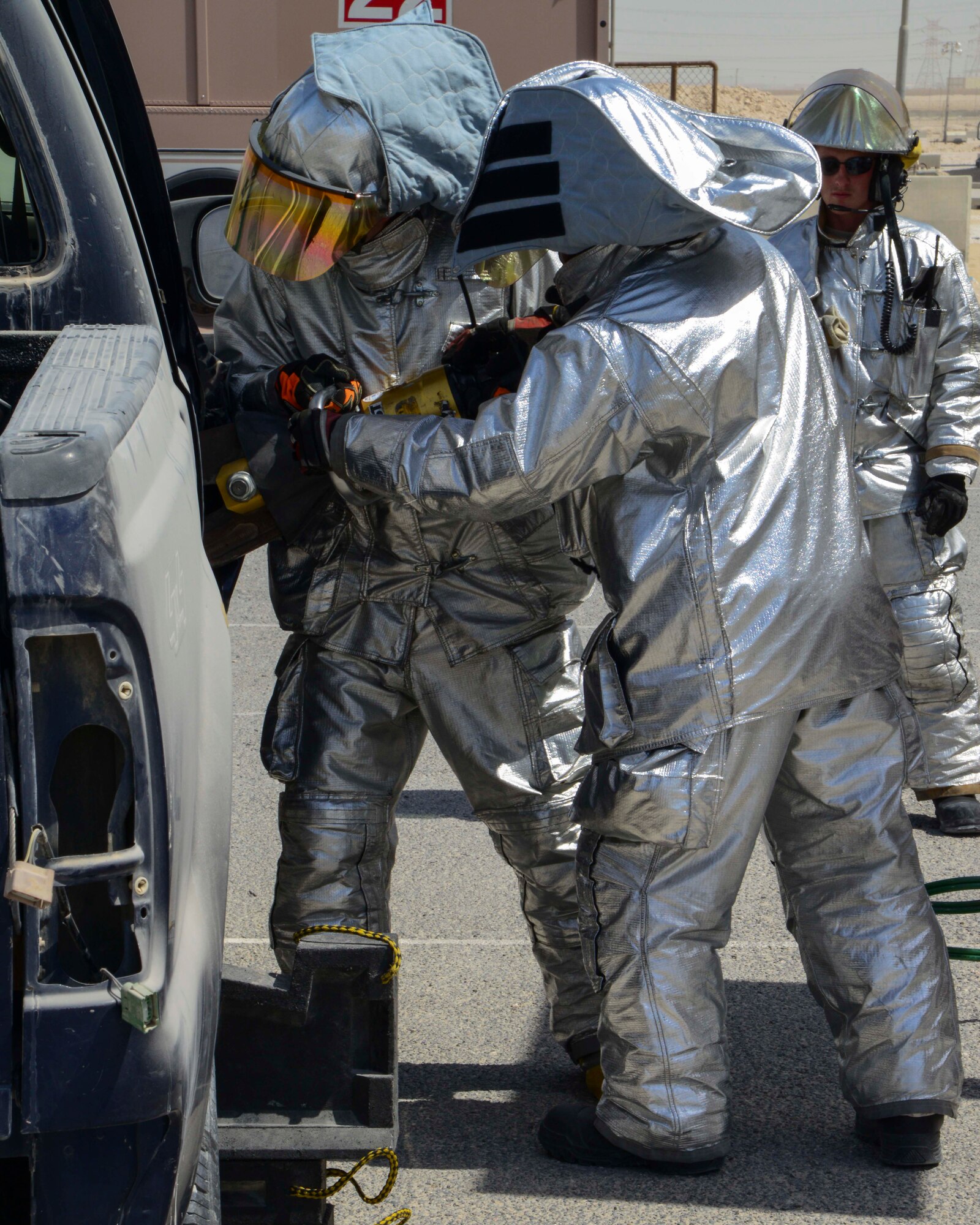 U.S. Air Force Airmen assigned to the 379th Expeditionary Civil Engineer Squadron prepare for a vehicle extrication demonstration at Al Udeid Air Base, Qatar, Oct. 8, 2014. Vehicle extrication is the result of a motor vehicle accident when conventional means of exit are impossible or inadvisable. (U.S. Air Force photo by Staff Sgt. Ciara Wymbs) 