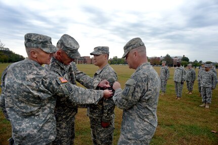 Army Maj. Gen. Judd H. Lyons, right, acting director of the Army National Guard, joins Army Col. Jayson Spade, left, commander of the 1st Information Operations Command (Land) and Army Lt. Gen. Edward Cardon, commander of Army Cyber Command and Second Army, in placing the Cyber Command shoulder sleeve insignia on the uniform of Army Maj. Hung Diep, commander of the 1636th Cyber Protection Team in a patch ceremony at Fort George G. Meade, Maryland, Tuesday Oct. 7, 2014. The 1636th CPT is the first Army National Guard cyber protection team to be activated and is one of 10 cyber protection teams planned throughout the Army Guard. 