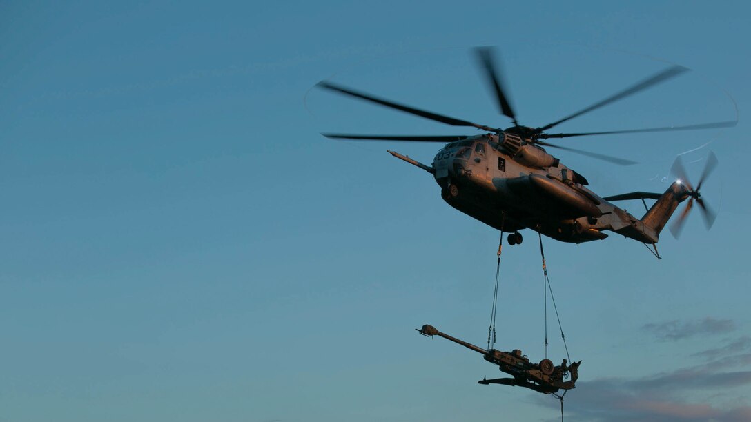 A CH-53E Super Stallion lowers a M777 Howitzer and its ammunition onto a landing zone aboard Marine Corps Base Camp Lejeune, N.C., as part of a reactionary combat training exercise Sept. 30, 2014. The purpose of the exercise was to build cohesion between and the aircraft’s crew and the Marines on the ground handling the equipment. (U.S. Marine Corps photo by Lance Cpl. Olivia C. McDonald/Released)