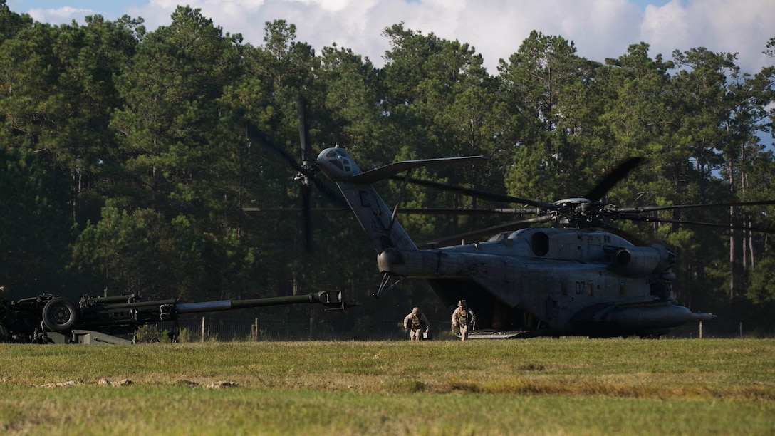 Marines disembark a CH-53E Super Stallion to prepare a M777 Howitzer for firing during a reactionary combat training exercise aboard Marine Corps Base Camp Lejeune, N.C., Sept. 30, 2014. The combined air-ground team used the training to build cohesion and improve their ability to rapidly deploy the weapon system in a combat environment. (U.S. Marine Corps photo by Lance Cpl. Olivia C. McDonald/Released)