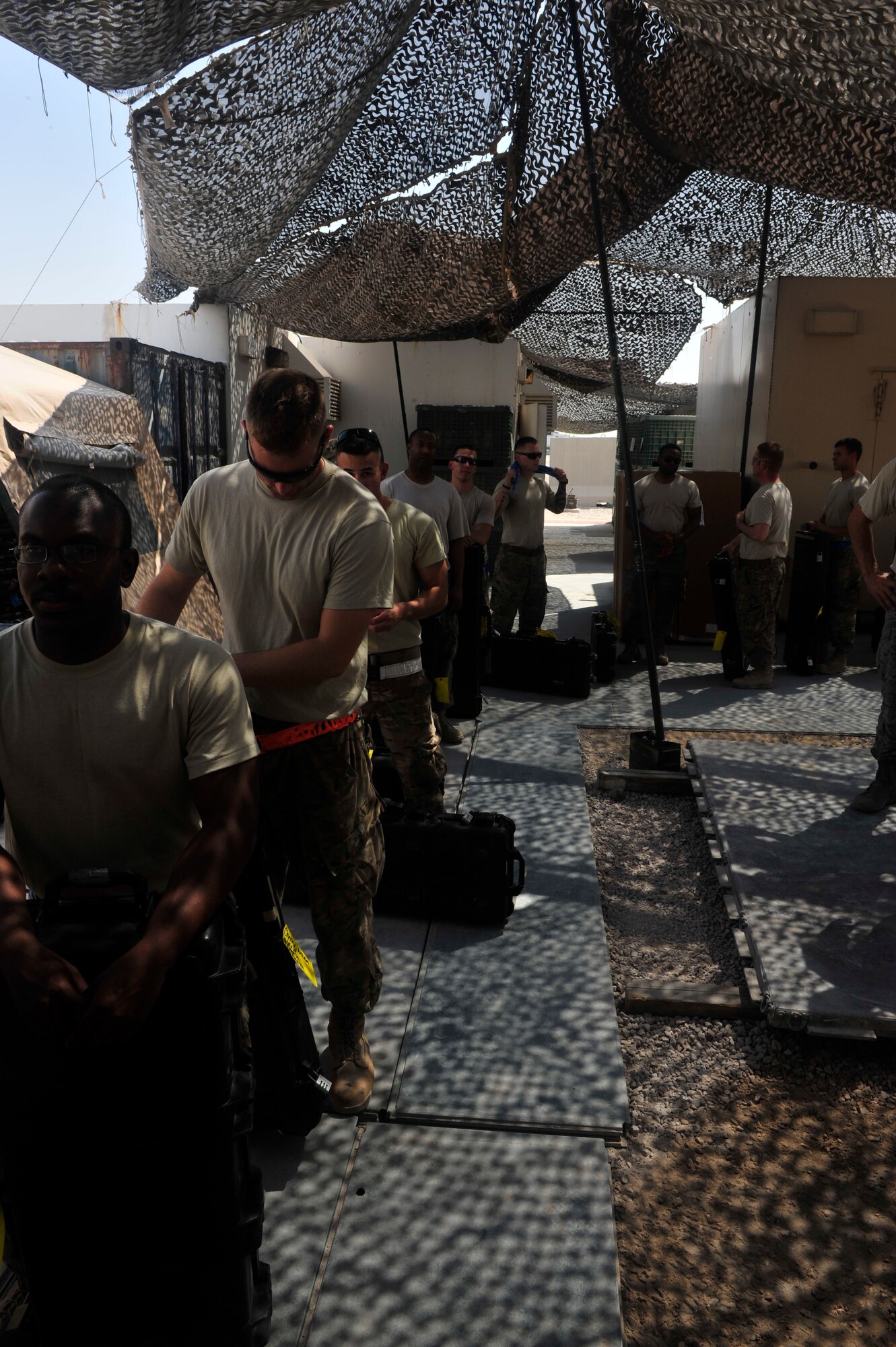 U.S. Air Force Airmen line up to be issued their weapons from the armory at Al Udeid Air Base, Qatar, Oct. 7, 2014. The armory provides a one-stop centralized and secure location for weapons distribution to all 379th Air Expeditionary Wing Airmen and Service members in transit through here.  (U.S. Air Force photo by Senior Airman Colin Cates) 