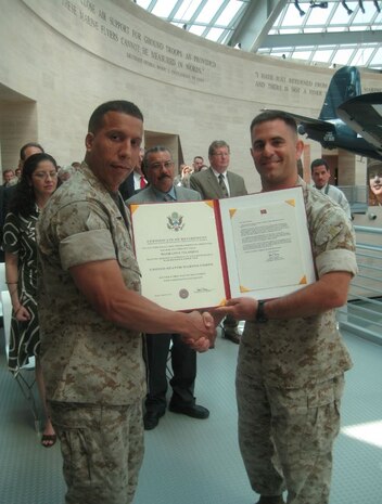 Maj. Luis Velazquez (left) displays his certificate of retirement in 2008 at the National Museum of the Marine Corps at Triangle, Virginia. Velazquez is now deputy modeling and simulations lead at Marine Corps Systems Command at Marine Corps Base Quantico, Virginia. 