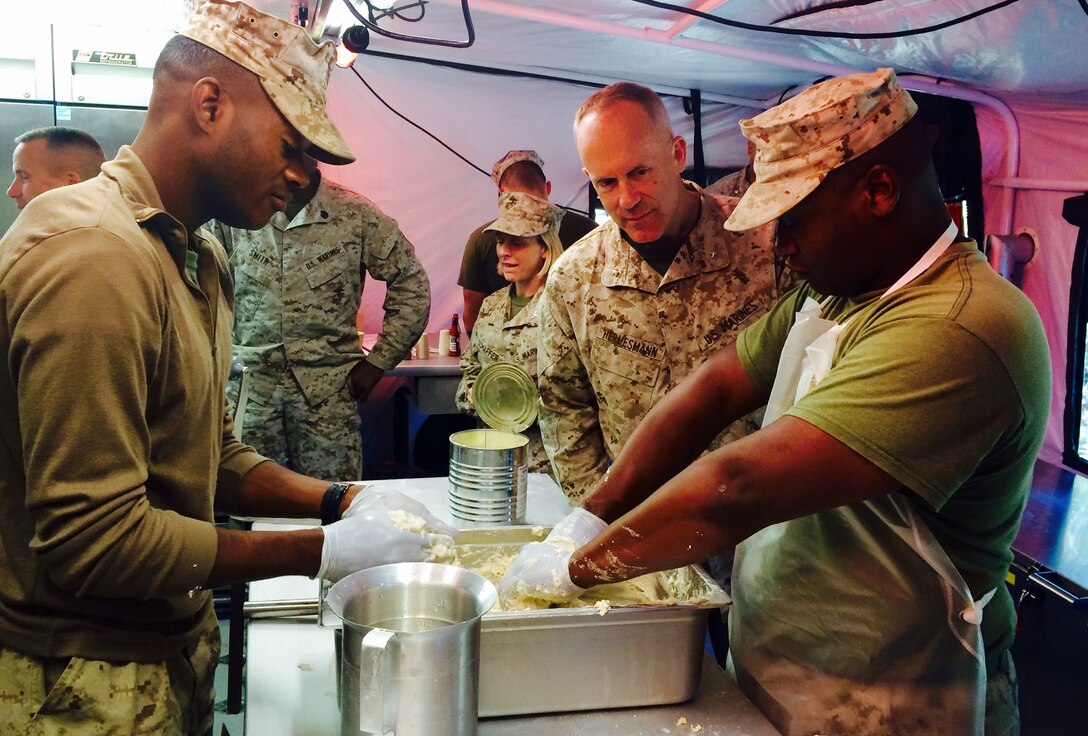 Cpl. Kevin D. Carson (left) and Lance Cpl. Anthony Davis, food service Marines with Combat Logistics Regiment 45, prepare and serve meals using the newest food service capability, the Expeditionary Field Kitchen during a training exercise at Ft. Benning, Ga. Brig. Gen. Patrick J. Hermesmann, commanding general of 4th Marine Logistics Group, visited the Marines from Oct. 2-5. This was the first time the regimental headquarters company had gone to the field.