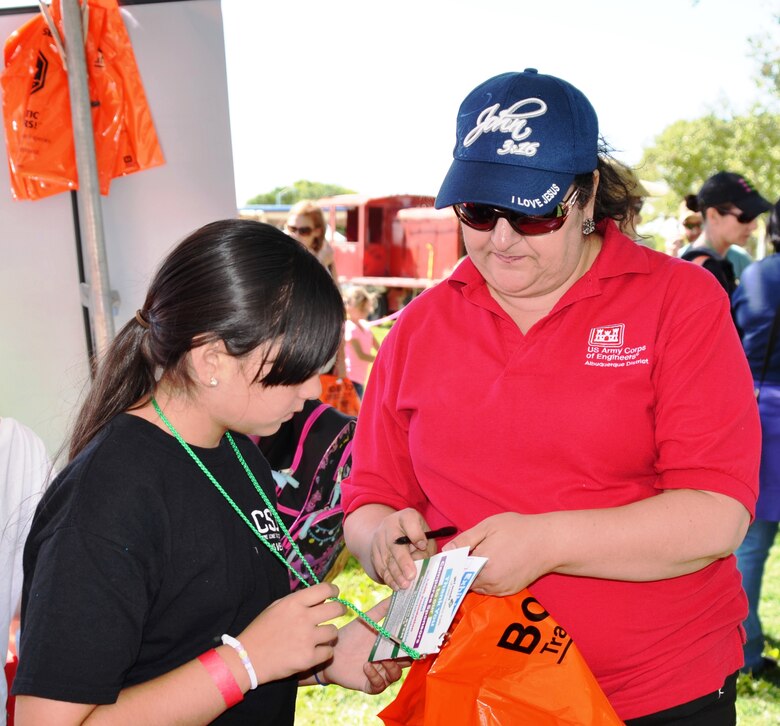 BERNALILLO, N.M., -- Jeannette Alderete assists a Girl Scout at the Corps’ STEM Camporee booth, Sept. 13, 2014.