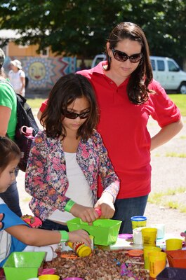 BERNALILLO, N.M., -- Amanda Tapia-Pittman watches as Girl Scouts design and build dams with gravel and playdough.