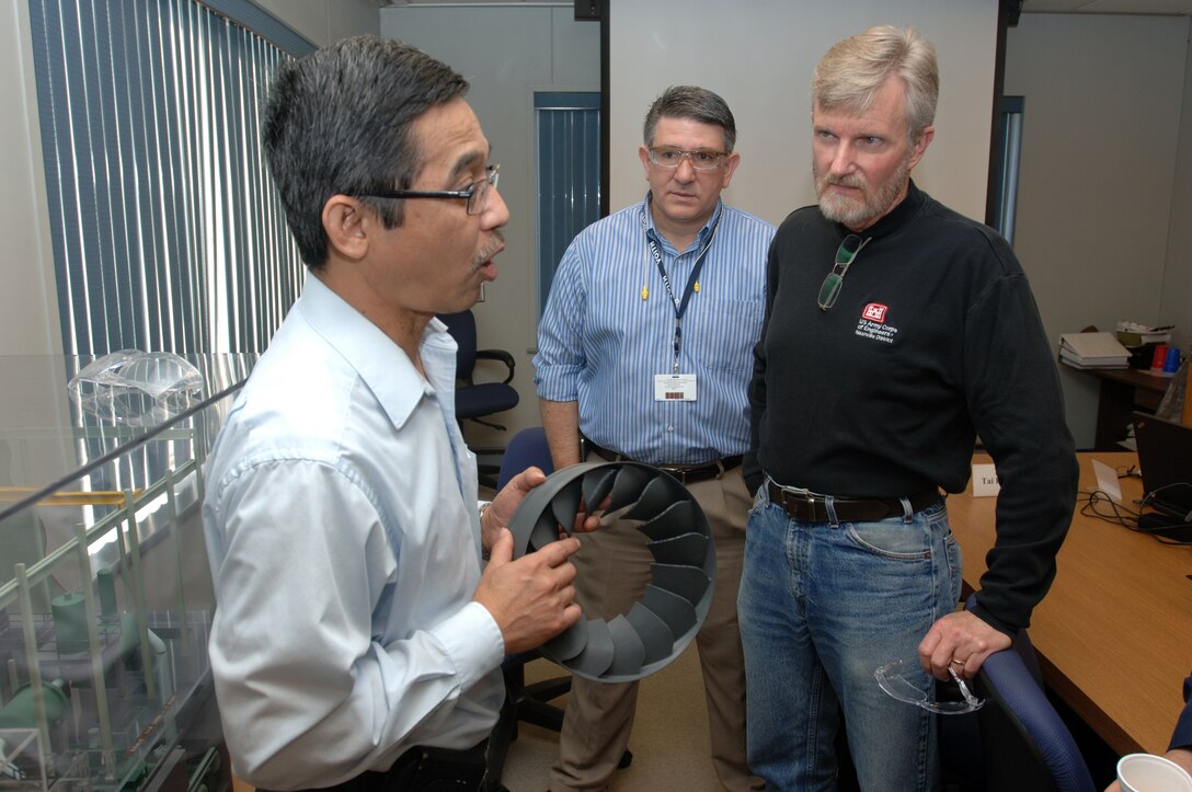 Tai Do (Left), Voith Hydro Hydraulic Laboratory manager, answers questions about an ongoing test of a turbine with Jamie James (Right), U.S. Army Corps of Engineers Nashville District Hydropower Rehabilitation Program manager, at the laboratory in York, Pa., Oct. 8, 2014.  Flavio Spadotto (Center), Voith Hydro project manager, also provided input.  James is part of a team that visited the lab to ensure the turbine meets required specifications before the manufacturing process and work to modernize the power house begins at Center Hill Dam in Lancaster, Tenn. 