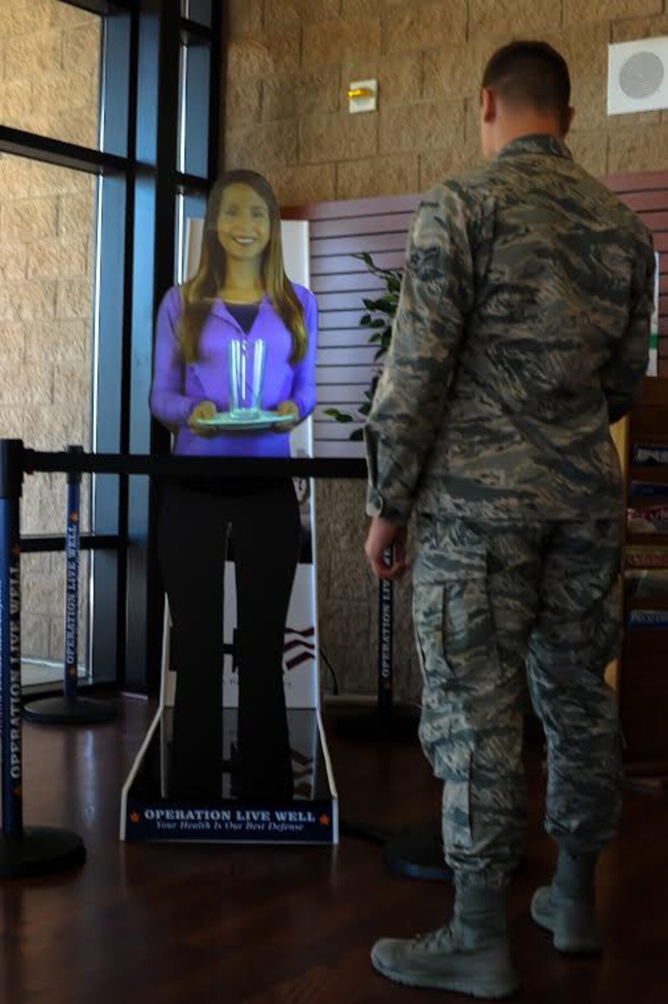 Airman 1st Class Jake Whalen, 366th Maintenance Group administrative executive, interacts with Holly-Graham before a workout at the Health and Wellness Center on Mountain Home Air Force Base, Idaho, Oct. 9, 2014. MHAFB is the first Air Force and second Department of Defense installation to receive Holly-Graham. She was brought here to share a variety of information on how to live a healthier lifestyle. (U.S. Air Force photo by Airman 1st Class Jeremy Mosier/RELEASED)