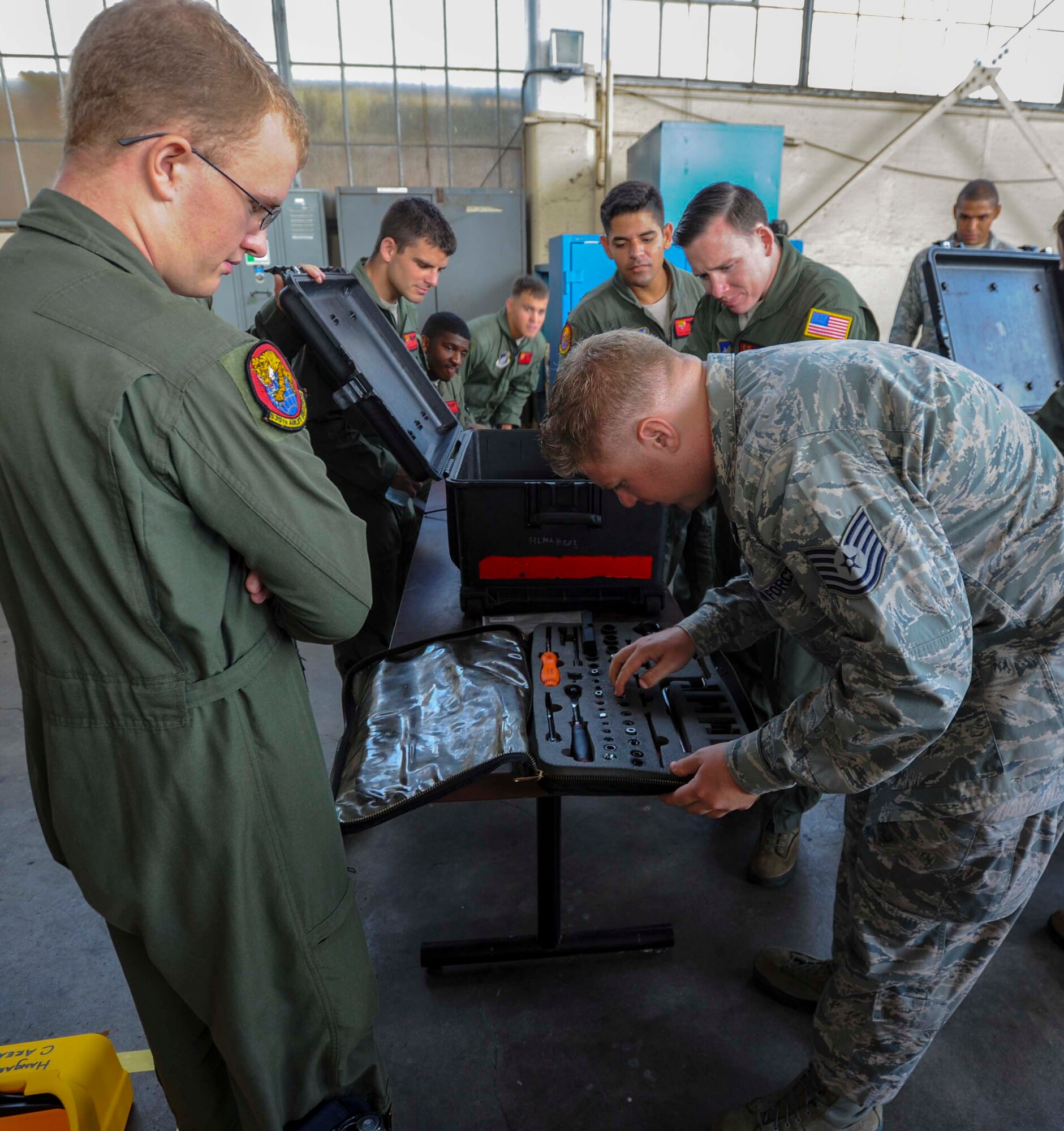 Members of the 535th Airlift Squadron look on as Tech. Sgt. Bob Wyman, 535th AS chief loadmaster, checks the contents of a tool box during a friendly competition as part of Operation Aircrew Orientation at Joint Base Pearl Harbor-Hickam, Hawaii, Oct. 9, 2014. Operation Aircrew offered members of the 535th Airlift Squadron a behind-the-scenes look at 735th Air Mobility Squadron operations. During the tour, aircrew members were educated on the inner workings of an air mobility squadron including passenger services, air freight, Air Terminal Operations Center and Air Mobility Command Control Center. (U.S. Air Force photo by Tech. Sgt. Terri Paden)