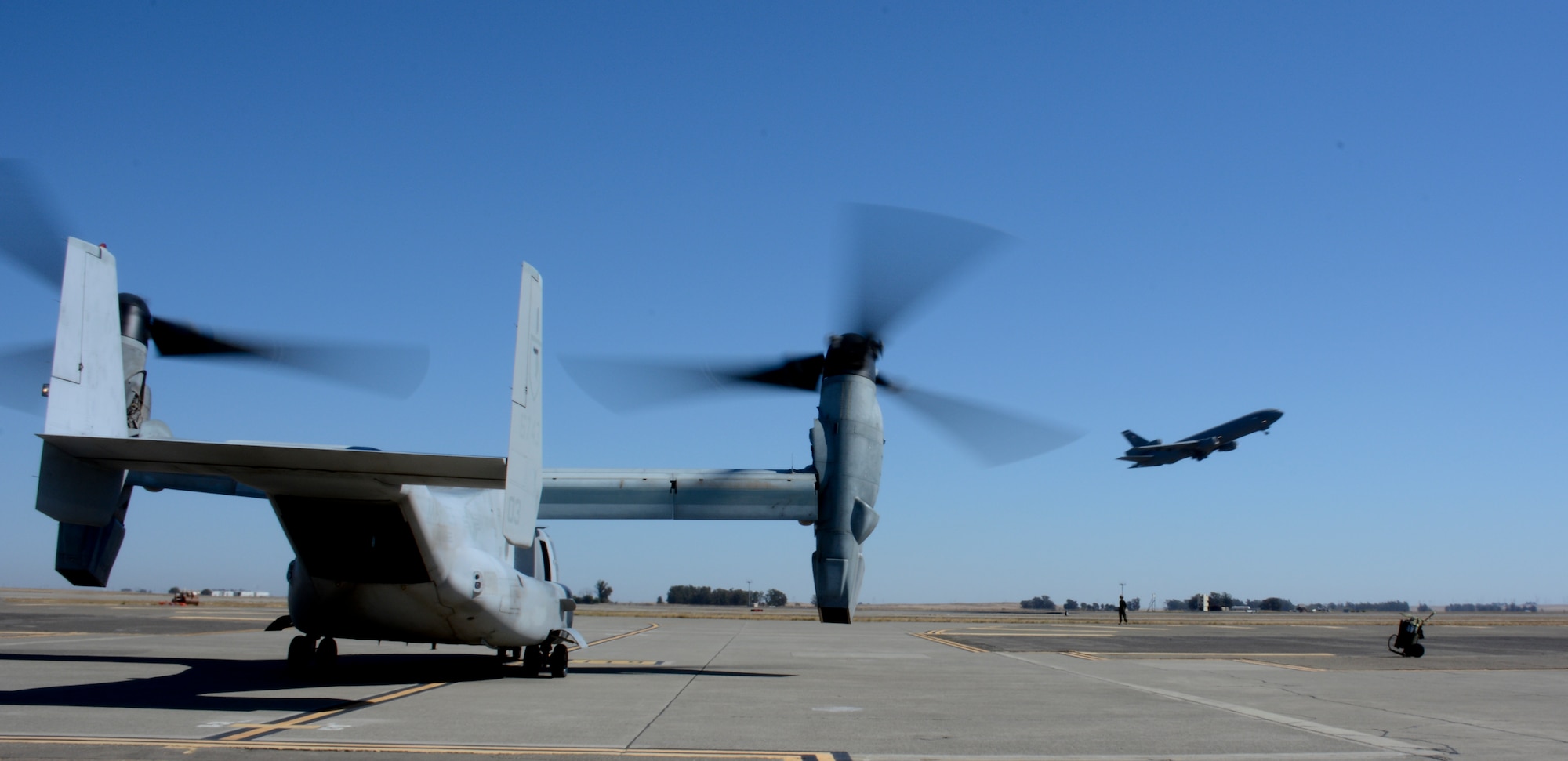 An MV-22 Osprey with the Marine Medium Tiltrotor Squadron 165 sits as a KC-10 Extender takes off Oct. 5 at Travis Air Force Base. (U.S. Air Force photo by Airman 1st Class Amber Carter)