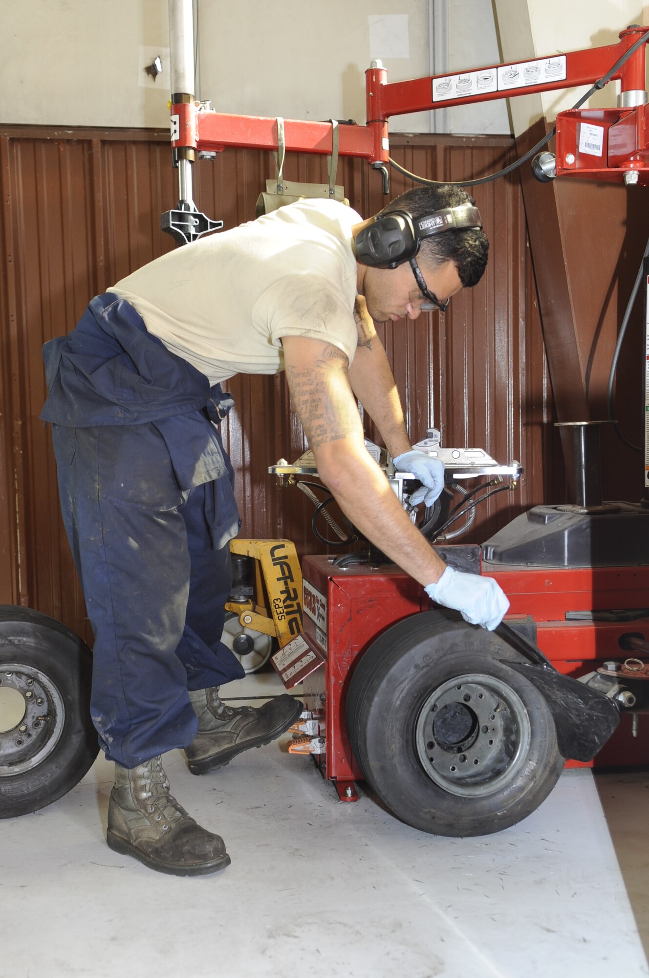 U.S. Air Force Staff Sgt. Ramiro Borja, 355th Equipment Maintenance Squadron aerospace ground equipment technician, removes a tire from its rim at Davis-Monthan Air Force Base, Ariz., Oct. 9, 2014. The AGE flight is responsible for maintaining the equipment that supplies electric, hydraulic and pneumatic power necessary to perform maintenance on the given aircraft. (U.S. Air Force photo by Airman 1st Class Betty R. Chevalier/Released)