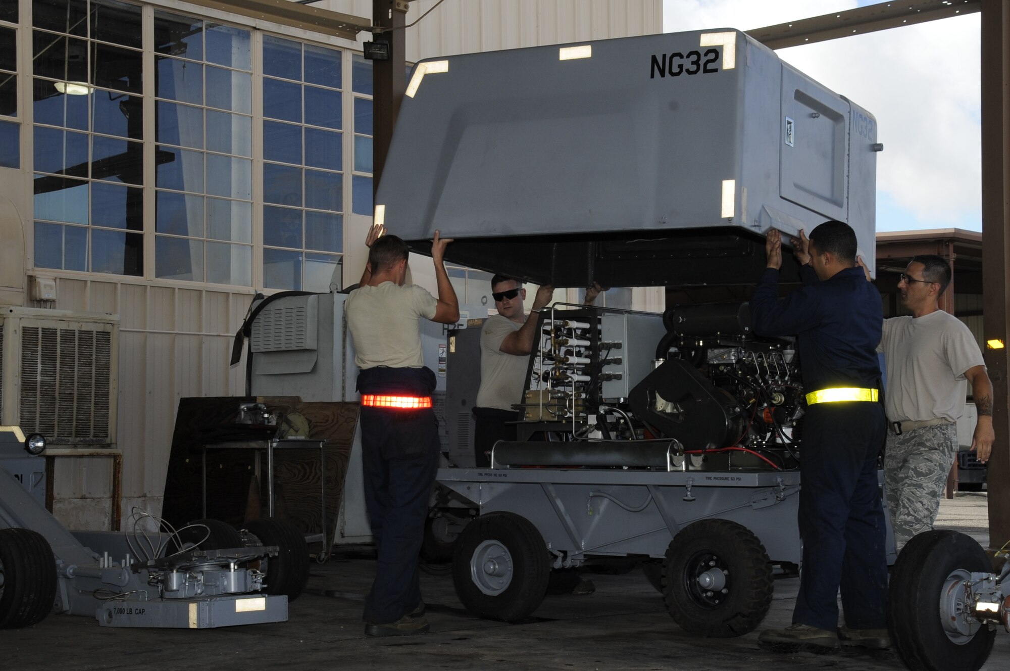 U.S. Air Force Airmen assigned to the 355th Equipment Maintenance Squadron aerospace ground equipment flight, remove the cover to a self-generating nitrogen cart at Davis-Monthan Air Force Base, Ariz., Oct. 9, 2014. The AGE flight is responsible for maintaining the equipment that supplies electric, hydraulic and pneumatic power necessary to perform maintenance on the given aircraft. (U.S. Air Force photo by Airman 1st Class Betty R. Chevalier/Released)