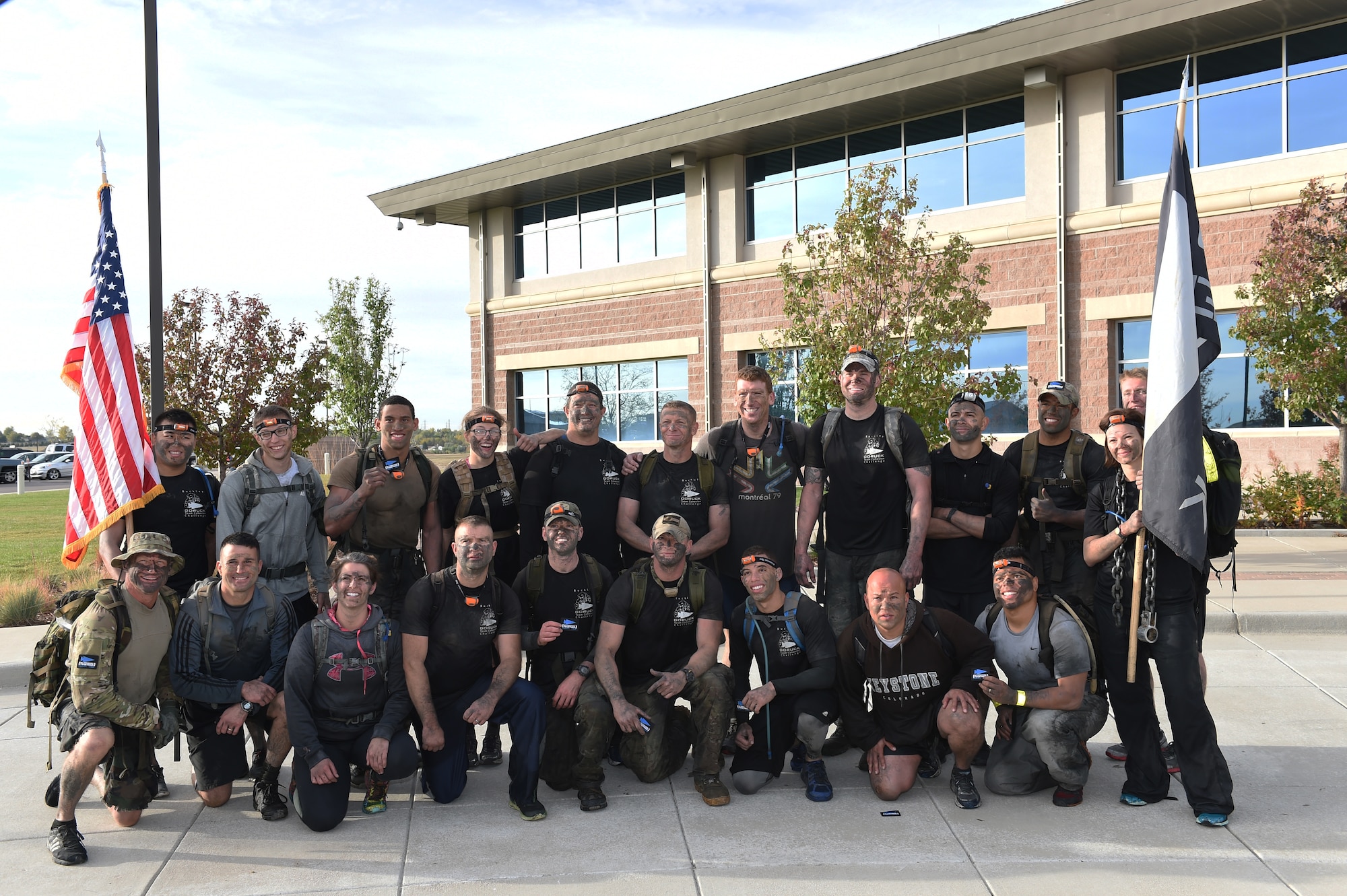 Team Buckley members pose for a final picture after a five-hour long ruck march through water drains and swimming through Lake Williams with 25-pound rucksacks on their backs Oct. 8, 2014 during the Team Cohesion Challenge on Buckley Air Force Base, Colo. The challenge, hosted by GORUCK, began long before sunrise and incorporated grueling special operations-type training activities. (U.S. Air Force photo by Airman 1st Class Samantha Saulsbury/Released)
