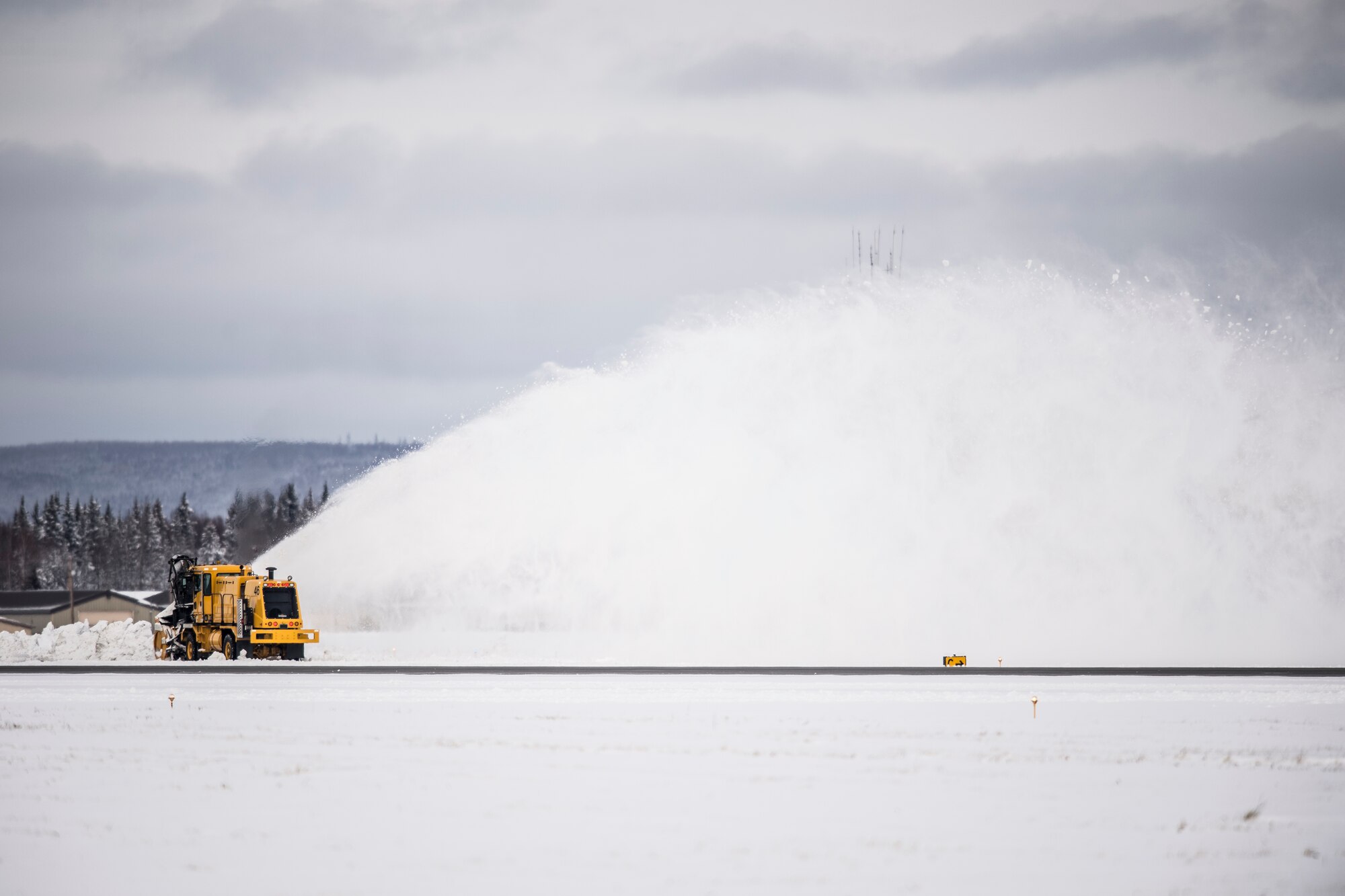 A 354th Civil Engineer Squadron snow broom clears a runway of snow and ice at Eielson Air Force Base, Alaska, Oct. 6, 2014, during RED FLAG-Alaska 15-1. 354th CES Dirt Boys ensured RF-A operations continued by clearing runways of a half-foot of snow that accumulated overnight. (U.S. Air Force photo by Senior Airman Peter Reft/Released)
