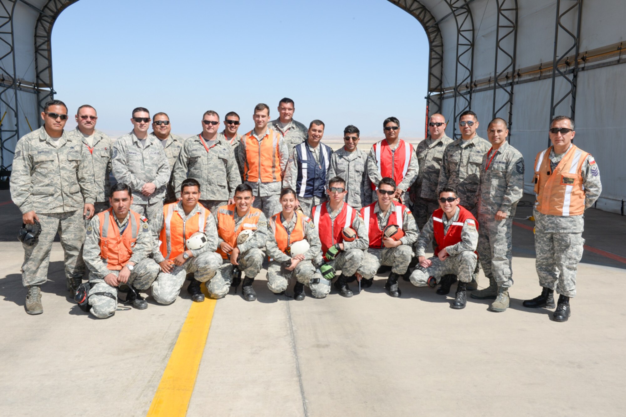 F-16 crew chiefs from the 149th Fighter Wing, Texas Air National Guard and the Chilean air force, work together during the State Partnership Program at Cerro Moreno Air Force Base, Chile, as part of a multi-national exercise, Salitre 2014, Oct. 10. Salitre is a Chilean-led exercise where the U.S., Chile, Brazil, Argentina and Uruguay, focus on increasing interoperability between allied nations. (Air National Guard photo by Senior Master Sgt. Miguel Arellano/released)