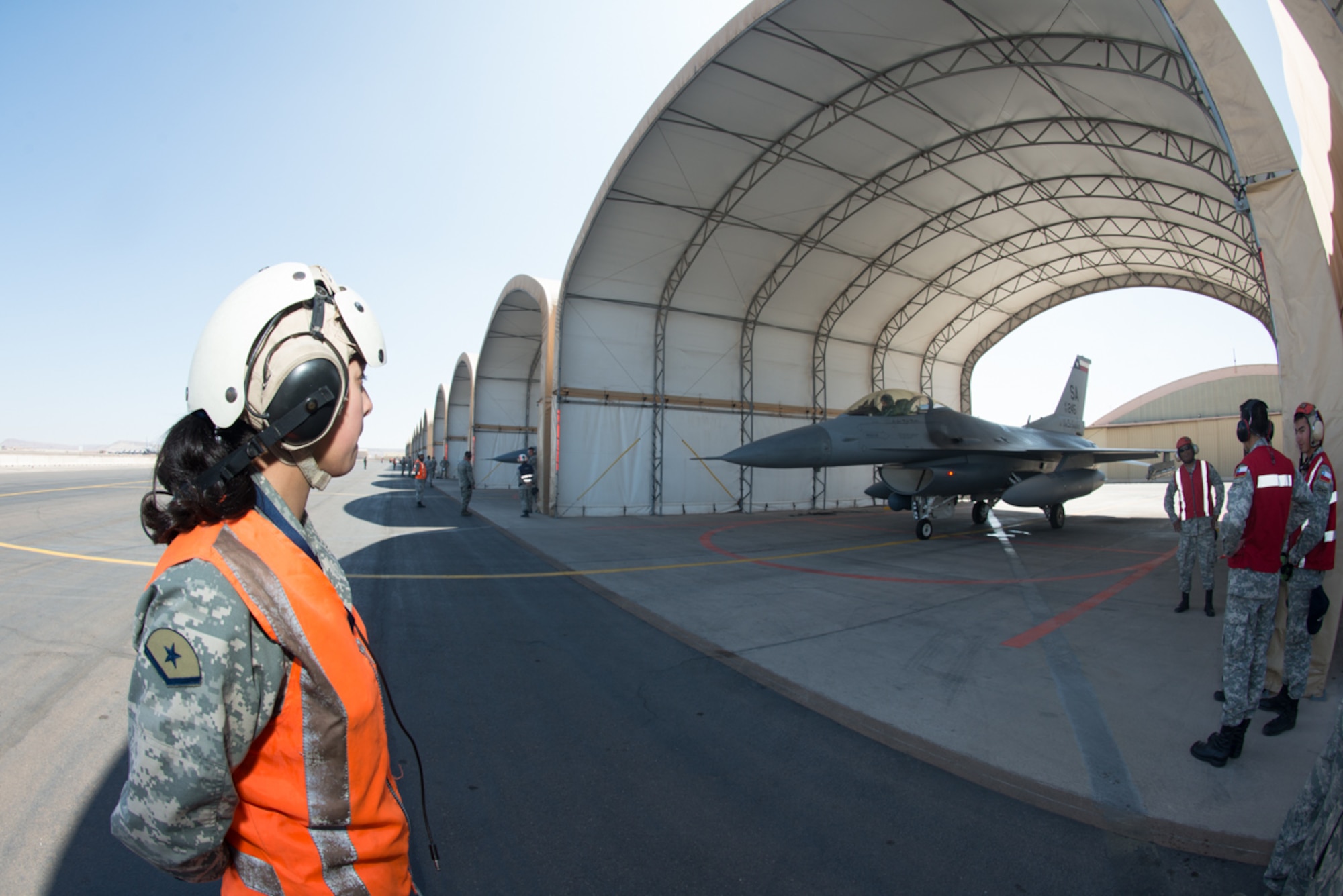 An F-16 crew chief from the Chilean air force prepares to taxi out an F-16 Fighting Falcon from the 149th Fighter Wing, Texas Air National Guard during the State Partnership Program at Cerro Moreno Air Force Base, Chile, as part of a multi-national exercise, Salitre 2014, Oct. 10. Salitre is a Chliean-led exercise event where the U.S. is participating as part of a larger coalition, combined team, focused on increasing interoperability. (Air National Guard photo by Senior Master Sgt. Elizabeth Gilbert/released)