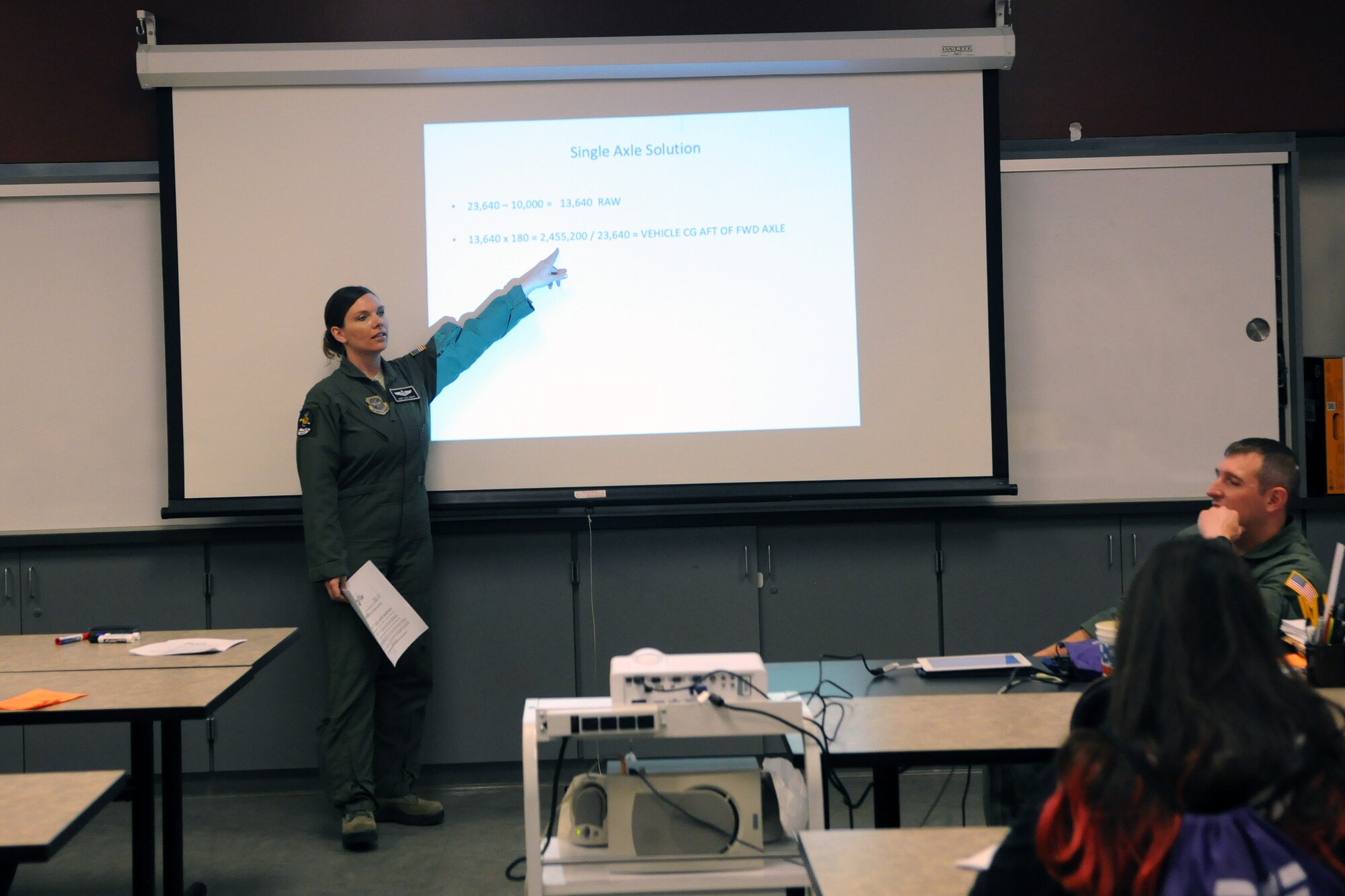 Staff Sgt. Lisa Knapp, 8th Airlift Squadron loadmaster, shows 8th-grade students how to perform an equation in order to load a vehicle into a C-17 Globemaster III, Oct. 9, 2014, during the Clover Park Technical College Math Conference in Lakewood, Wash. The math sessions were held to show students real-life application of math in the Air Force. (U.S. Air Force photo/Airman 1st Class Jacob Jimenez)     