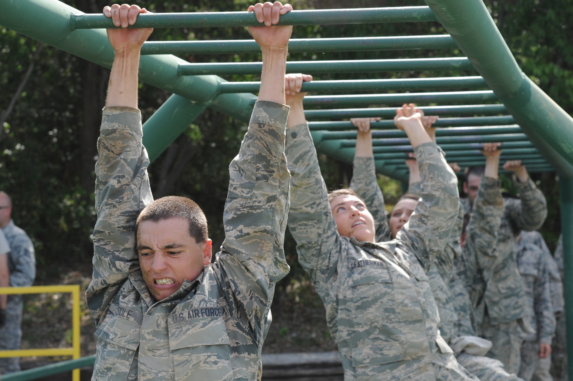 Basic military trainees cross monkey bars over a pool of water as part of the basic military training obstacle course at Joint Base San Antonio-Lackland, Sept. 24, 2014. The obstacle course was about a mile to a mile and a half long depending on what 14 obstacles were open; the two water obstacles would close seasonally. The course, which closed Sept. 24, was replaced by new one, called the Leadership Reaction Course, which was added to basic expeditionary Airmen’s training, also known as BEAST week, at JBSA-Lackland Medina Annex and became fully operational Sept. 29. (U.S. Air Force photo by Senior Airman Krystal Jeffers/Released)