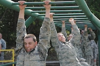 Basic military trainees cross monkey bars over a pool of water as part of the basic military training obstacle course at Joint Base San Antonio-Lackland, Sept. 24, 2014. The obstacle course was about a mile to a mile and a half long depending on what 14 obstacles were open; the two water obstacles would close seasonally. The course, which closed Sept. 24, was replaced by new one, called the Leadership Reaction Course, which was added to basic expeditionary Airmen’s training, also known as BEAST week, at JBSA-Lackland Medina Annex and became fully operational Sept. 29. (U.S. Air Force photo by Senior Airman Krystal Jeffers/Released)