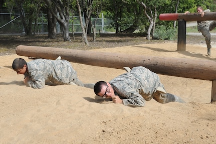 Basic military trainees craw under and over logs as a part of the basic military training obstacle course at Joint Base San Antonio-Lackland, Sept. 24, 2014. The obstacle course was about a mile to a mile and a half long depending on what 14 obstacles were open; the two water obstacles would close seasonally. The course, which closed Sept. 24, was replaced by new one, called the Leadership Reaction Course, which was added to basic expeditionary Airmen’s training, also known as BEAST week, at JBSA-Lackland Medina Annex and became fully operational Sept. 29. (U.S. Air Force photo by Senior Airman Krystal Jeffers/Released)