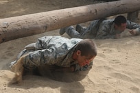 Basic military trainees crawl under and over logs part of the basic military training obstacle course Sept. 24, 2014 at Joint Base San Antonio-Lackland. The obstacle course was about a mile to a mile and a half long depending on what 14 obstacles were open. The two water obstacles were closed seasonally. The course was permanently closed the same day and new one was integrated into the Creating Leaders, Airmen, and Warriors – or CLAW – mission and became fully operational Sept. 29. (U.S. Air Force photo by Senior Airman Krystal Jeffers/Released)