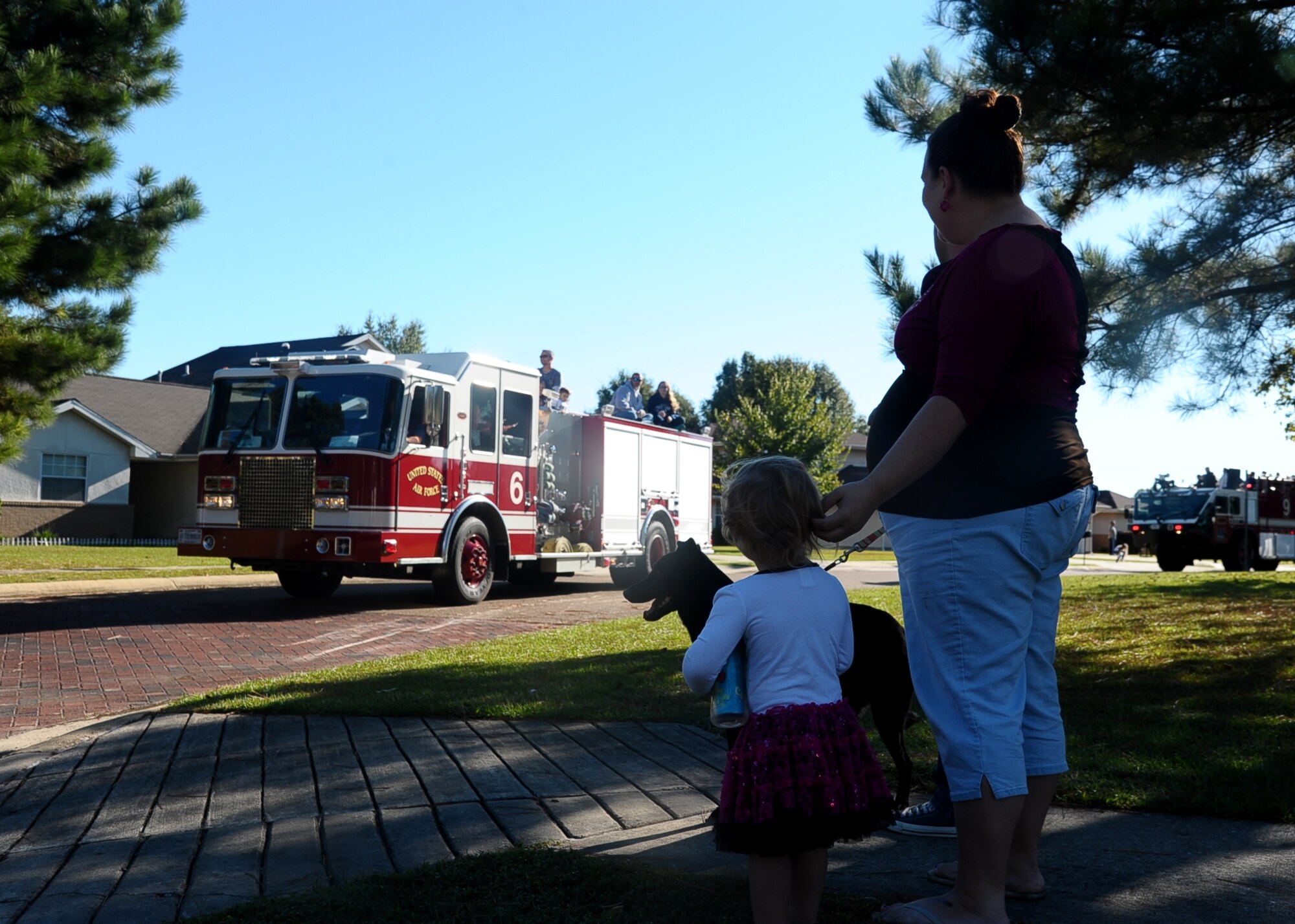 Kayleen and Aleah, daughter and wife (respectively) of Senior Airman Thomas Ramirez, 14th Comptroller Squadron, look on as fire trucks blared their way through Hunt Family Housing Oct. 4 for the Fire Prevention Week Parade and Open House. This year’s theme for Fire Prevention Week was working smoke alarms save lives. The Fire Department held numerous events and activities to teach children and adults how to be safe in emergency situations and to demonstrate the Fire Department’s capabilities. (U.S. Air Force photo/Senior Airman Stephanie Englar)