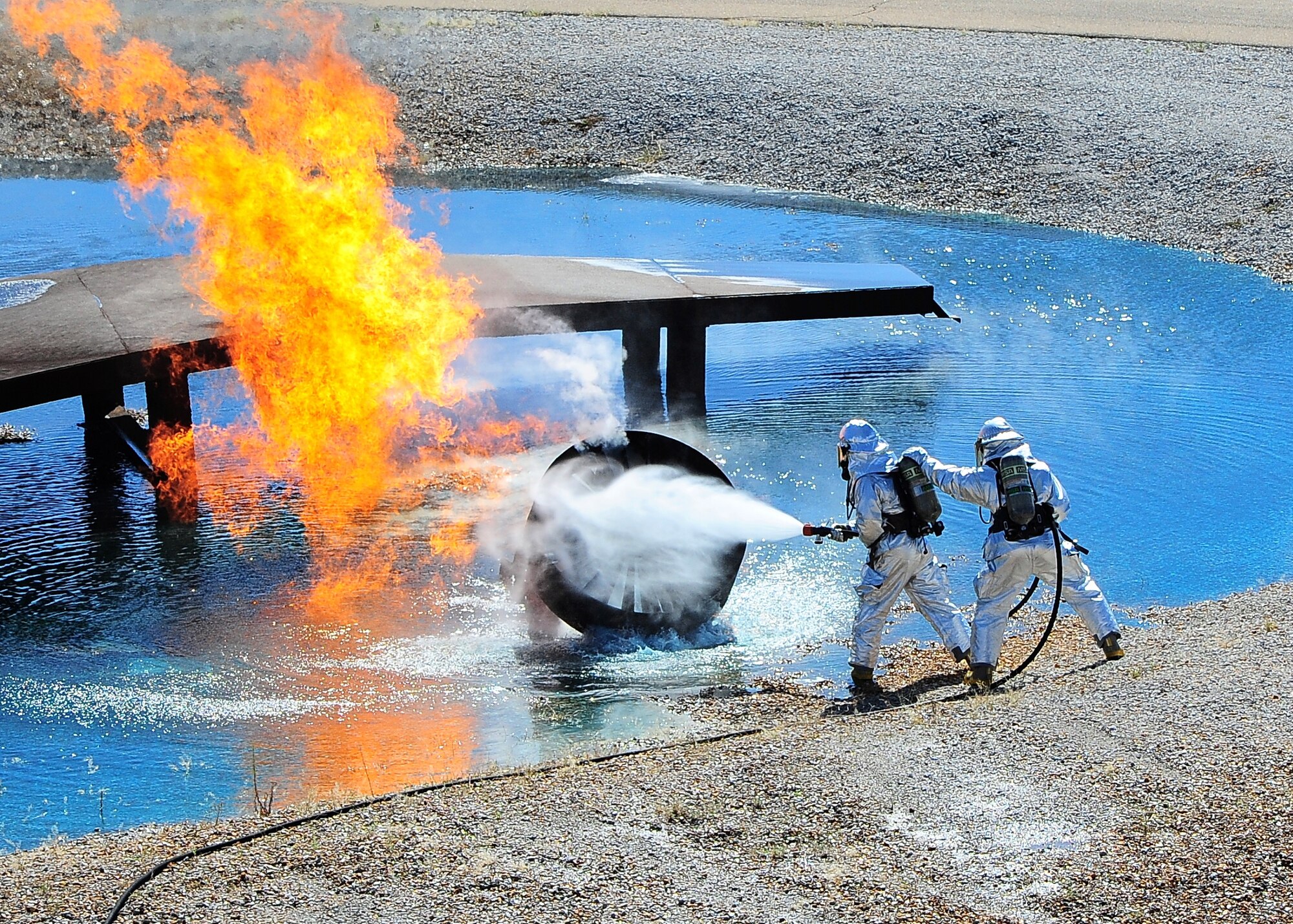 Senior Airman Andrew Vasvaritoke and Airman1st Class David Patterson, both firefighters with the 14th Civil Engineer Squadron, work together to put out a fire during a live controlled burn at the Fire Prevention Week Open House Oct. 4 at the Fire Station. The live controlled burn demonstrates the fire department’s skills and capabilities in putting out fires. (U.S. Air Force photo/Airman Daniel Lile) 