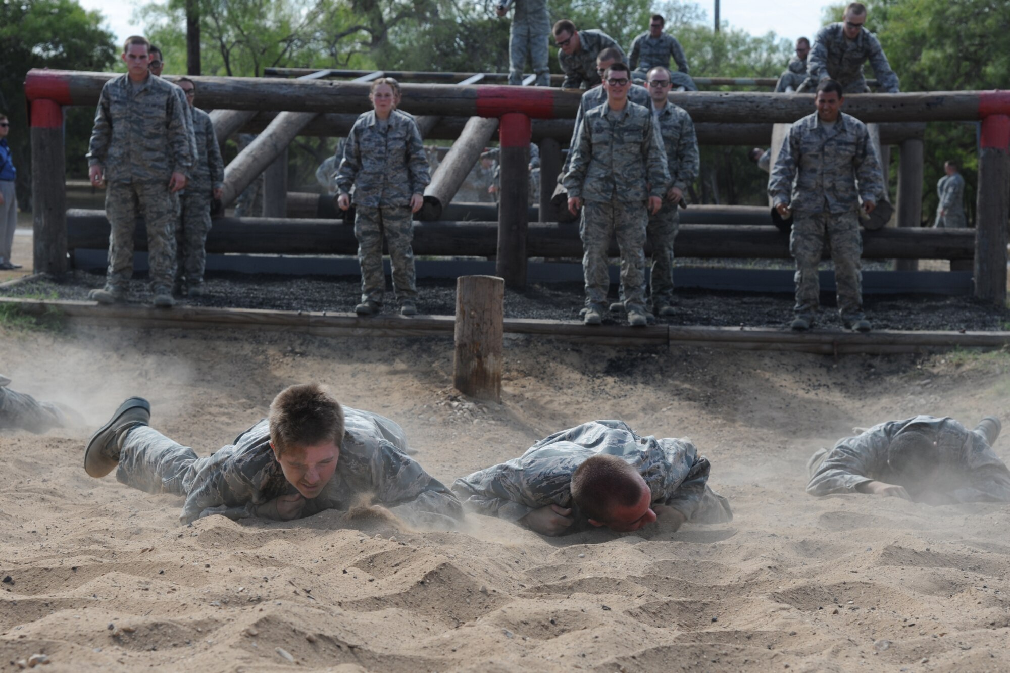 Basic military trainees low craw through sand as part of the basic military training obstacle course at Sept. 24, 2014, Joint Base San Antonio-Lackland. The mile-and-a-half long course, which permanently closed the same day, was replaced with the ‘Leadership Reaction Course’ at JBSA-Lackland Medina Annex, which became fully operational Sept. 29. The new course was integrated into the Creating Leaders, Airmen, and Warriors – or CLAW – mission which is part of the basic expeditionary Airmen’s training, also known as BEAST week. (U.S. Air Force photo by Senior Airman Krystal Jeffers/Released)