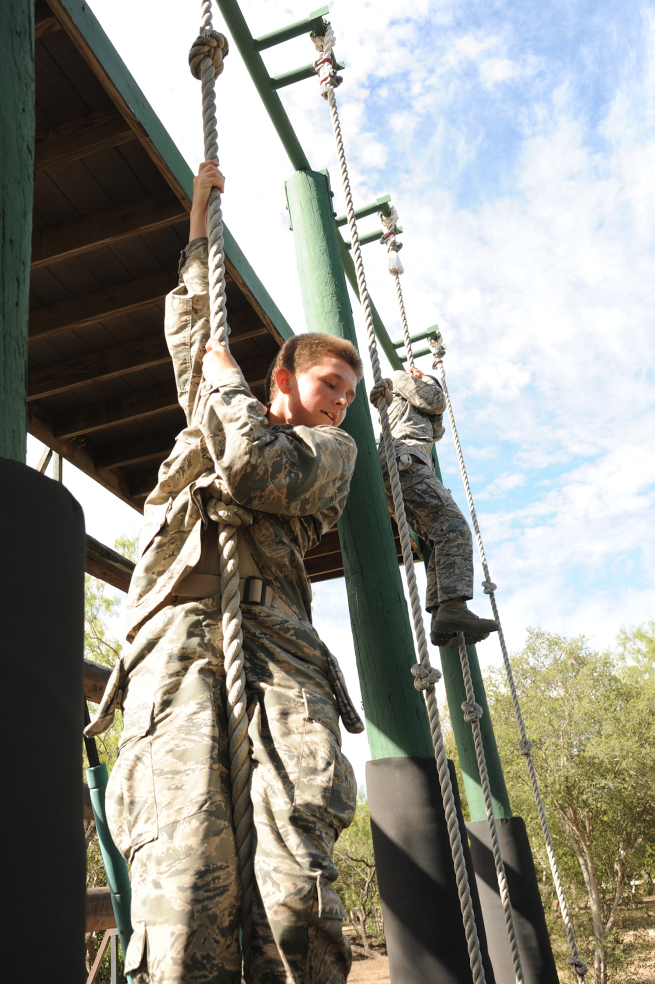 Basic military trainees slide down 14 feet with a rope as part of the basic military training obstacle course at  Sept. 24, 2014 Joint Base San Antonio-Lackland. The course, which closed permanently the same day, was replaced with the ‘Leadership Reaction Course’ at JBSA-Lackland Medina Annex. The new course became operational Sept. 29, and was integrated into the Creating Leaders, Airmen, and Warriors – or CLAW – mission which is part of the basic expeditionary Airmen’s training, also known as BEAST week during BMT. (U.S. Air Force photo by Senior Airman Krystal Jeffers/Released)