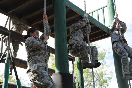 Basic military trainees slide down 14 feet with a rope as part of the basic military training obstacle course at Joint Base San Antonio-Lackland, Sept. 24, 2014. The course, which closed permanently the same day, was replaced with the Leadership Reaction Course at JBSA-Lackland Medina Annex. The new course became operational Sept. 29, and was integrated into the Creating Leaders, Airmen, and Warriors – or CLAW – mission which is part of the basic expeditionary Airmen’s training, also known as BEAST week during BMT. (U.S. Air Force photo by Senior Airman Krystal Jeffers/Released)