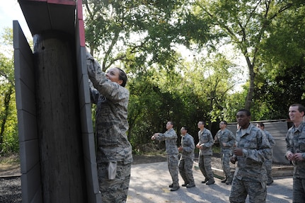 Trainees attempt to climb over one of the obstacles at the basic military training obstacle course Sept. 24, 2014 at Joint Base San Antonio-Lackland. The trainees completed the last run of mile-and-a-half long course before its permanent closure the same day.  A new course, called the Leadership Reaction Course, was integrated into Air Force Basic Military Training’s Creating Leaders, Airmen, and Warriors mission. The CLAW is part of the basic expeditionary Airmen’s training, also known as BEAST week, at JBSA-Lackland Medina Annex and became fully operational Sept. 29. (U.S. Air Force photo by Senior Airman Krystal Jeffers/Released)