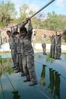 Basic military trainees slide across a rope above a pool of water as part of the obstacle course at Joint Base San Antonio-Lackland, Sept. 24, 2014. The obstacle course was about a mile to a mile and a half long depending on what of the 14 obstacles were open.. That was the last use of the obstacle course, which closed and was replaced by new course, called the Leadership Reaction Course, that was added to basic expeditionary Airmen’s training, also known as BEAST week, at JBSA-Lackland Medina Annex and became fully operational Sept. 29. (U.S. Air Force photo by Senior Airman Krystal Jeffers/Released)