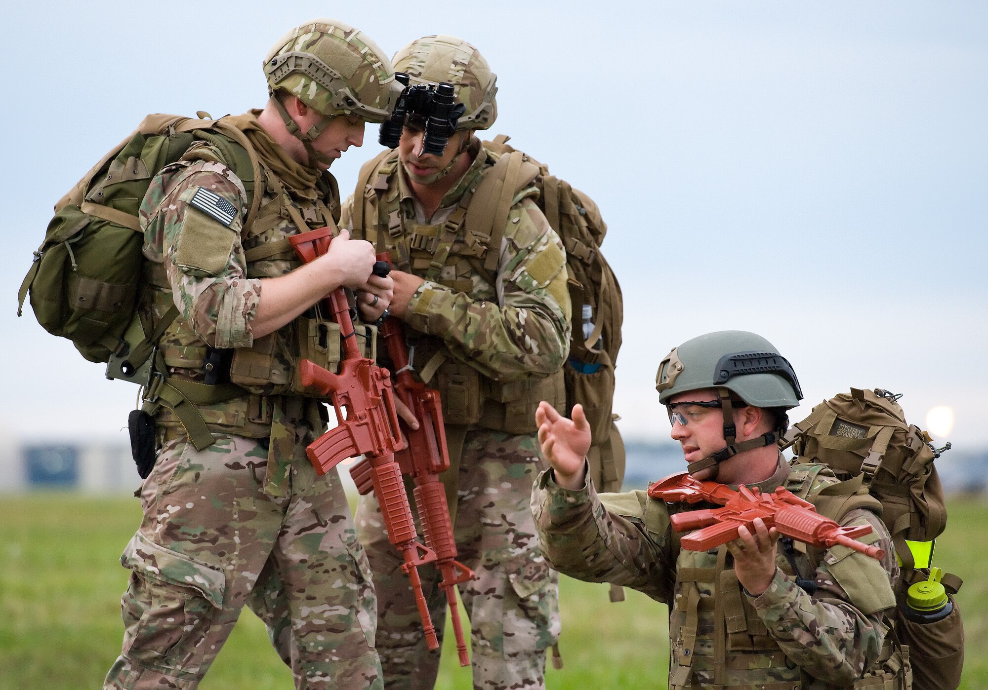 Airman 1st Class Colby Hillman, left, and Staff Sgt. Donald Manuel, center, simulate calling in position coordinates for close air support while Staff Sgt. Carl Dill points to  the direction of simulated hostile fire Oct. 10, 2014, on Dover Air Force Base, Del. All three are member of the 436th Civil Engineer Squadron Explosive Ordnance Disposal Flight (U.S. Air Force photo/Roland Balik)