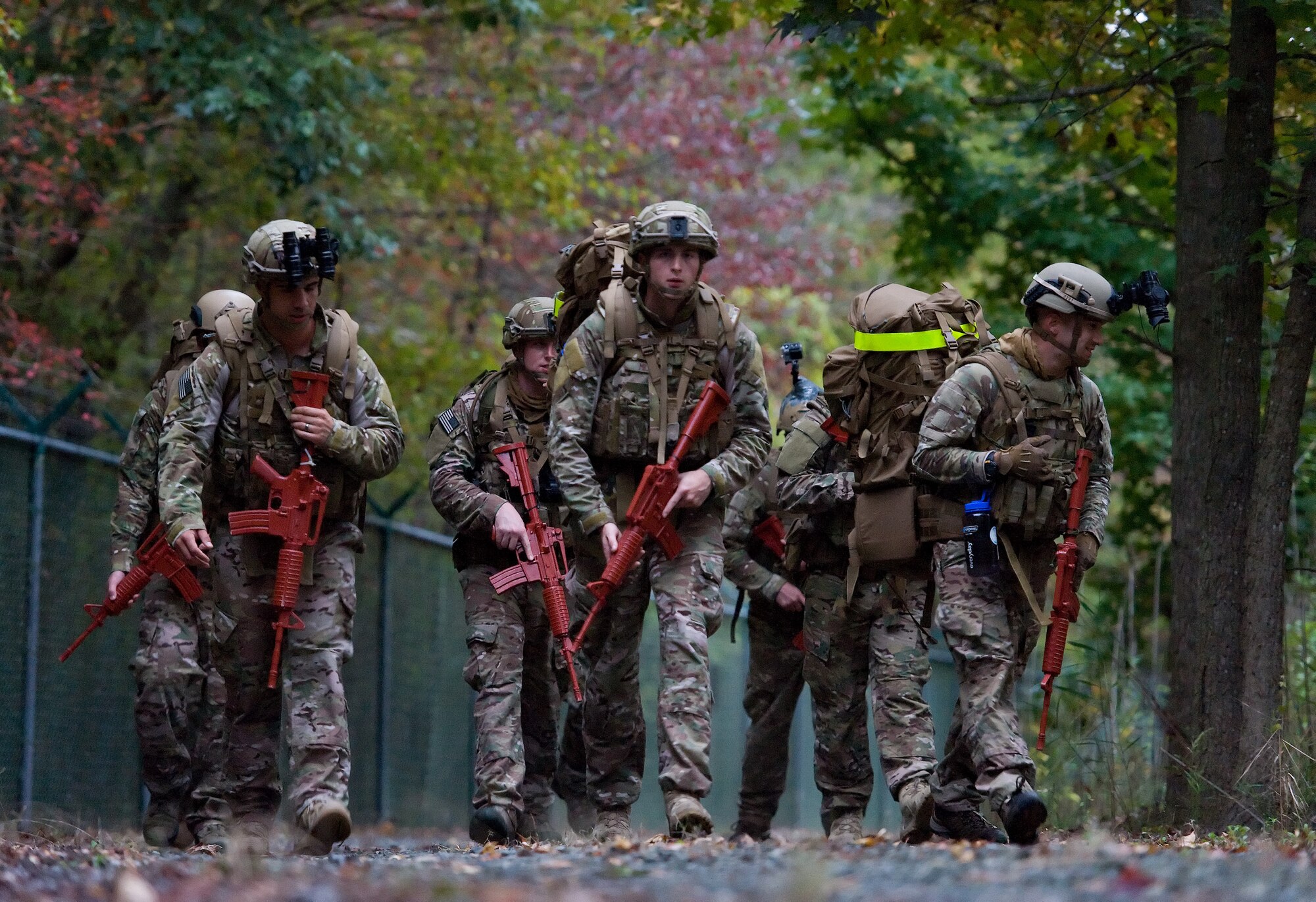 Members of the 436th Civil Engineer Squadron Explosive Ordnance Disposal Flight walk along the perimeter fence Oct. 10, 2014, on Dover Air Force Base, Del. During a three-mile long soldiering skills training event, EOD flight personnel practiced body armor set-up, ruck sack configuration, night vision goggle usage, troop movement techniques, noise discipline, hand and arm signals, react to contact, casualty carries and securing a landing zone. (U.S. Air Force photo/Roland Balik)