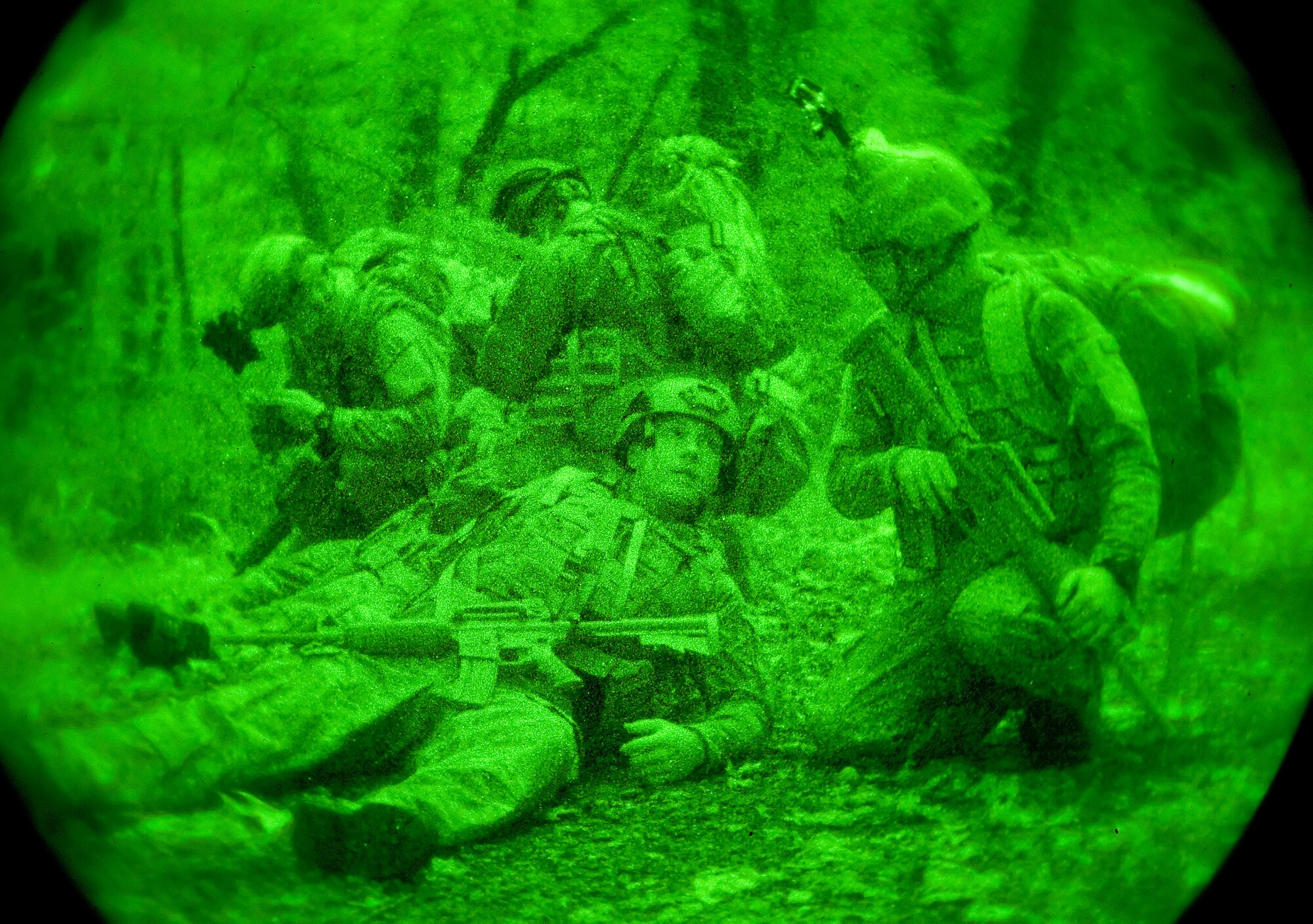 Senior Airman Michael Poffenberger, right, and Airman 1st Class Cody Grassie, center, both 436th Civil Engineer Squadron Explosive Ordnance Disposal technicians, talk to each other after coming under a simulated attack during a three-mile patrol Oct. 10, 2014, on Dover Air Force Base, Del. Grassie and another EOD technician simulated being wounded which required them to be carried to a landing zone for extraction by a helicopter. (U.S. Air Force photo/Roland Balik)