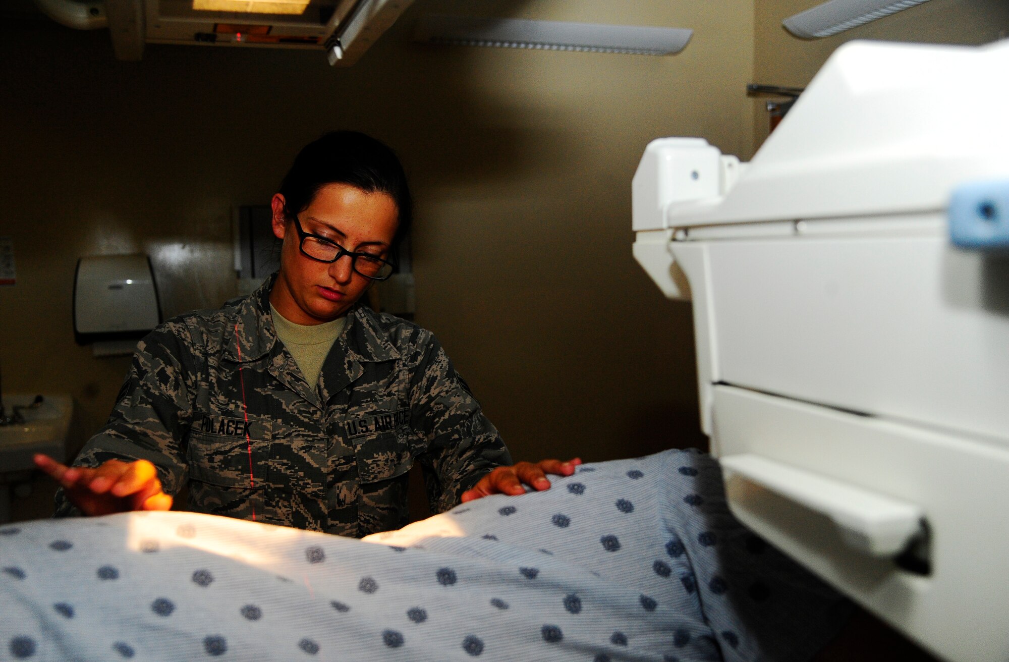 Airman 1st Class Jessica Polacek, Phase II radiology technologist student, positions a patient for a lower back x-ray Oct. 9, 2014 at MacDill Air Force Base, Fla. MacDill is home to one of 11 Radiology Phase II Technical Schools in the Air Force. (U.S. Air Force photo by Senior Airman Jenay Randolph/Released)