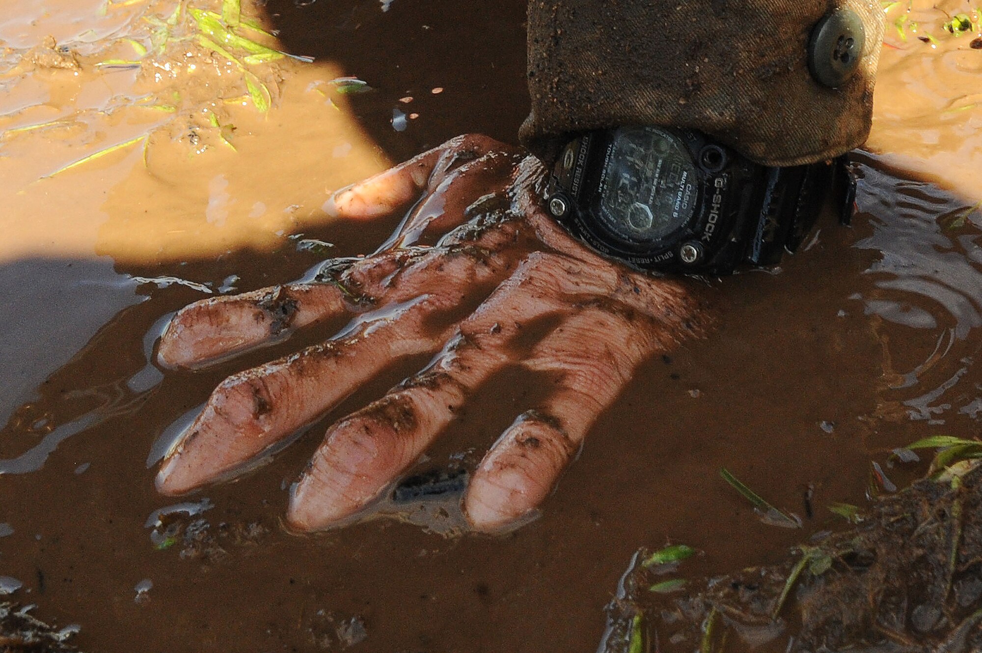 A U.S. Air Force Airman’s hand is covered in mud while performing a push-up during a Defenders Edge Challenge at Shaw Air Force Base, S.C., Oct. 8, 2014. After the challenge was complete, awards were given to the best team leader, best team member, best shooter, and top three teams. (U.S. Air Force photo by Airman 1st Class Michael Cossaboom/Released)