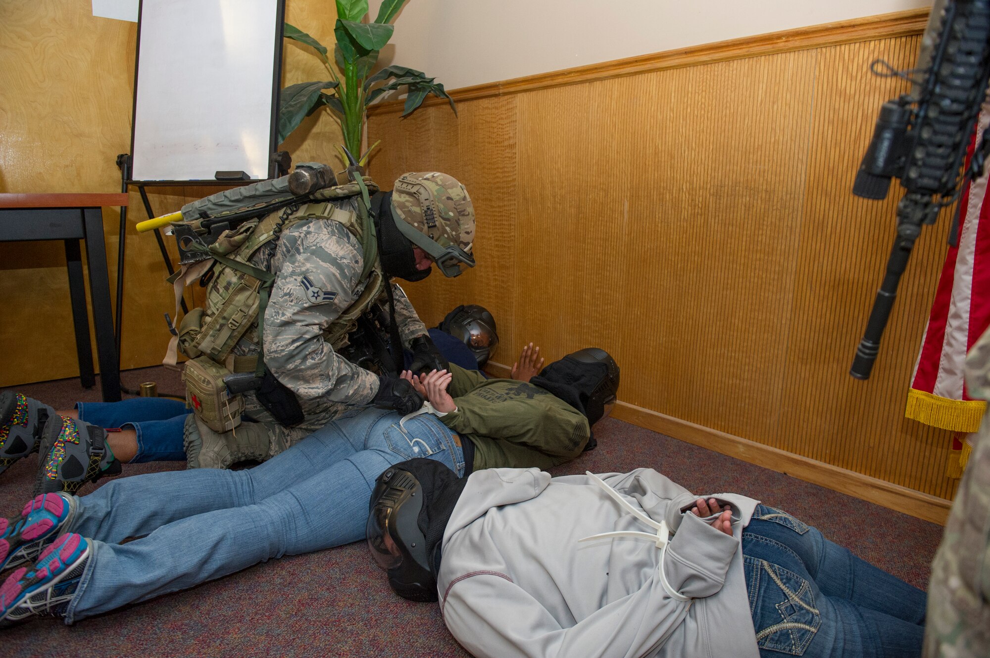 A member of the 49th Security Forces Squadron checks the welfare of hostage participants during an active shooter exercise at Holloman Air Force Base, N.M., Oct. 9. Holloman maintains readiness to respond to emergencies such as active shooters by conducting training exercises multiple times a year. Members from the 49th Security Forces Squadron, 49th Civil Engineer Squadron and the 49th Medical Group were able to quickly respond to the exercise scenario, neutralize the threats and evacuate the victims. (U.S. Air Force photo by Airman 1st Class Aaron Montoya / Released)