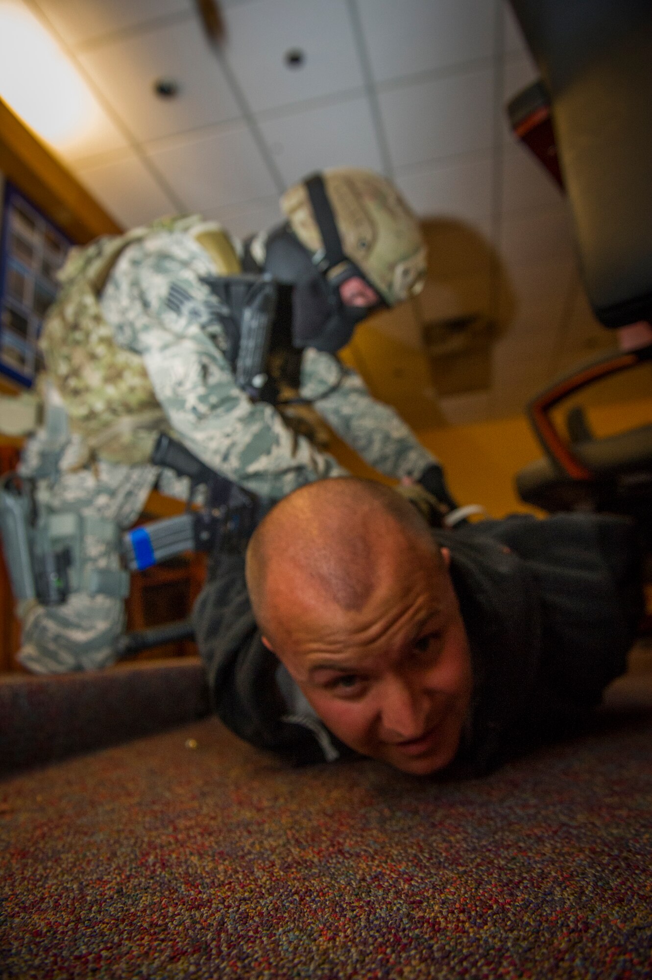 A member of the 49th Security Forces Squadron subdues a hostile player during an active shooter exercise at Holloman Air Force Base, N.M., Oct. 9 Holloman exercises to maintain readiness in order to respond to emergencies such as active shooters. Members from the 49th Security Forces Squadron, 49th Civil Engineer Squadron and the 49th Medical Group were able to quickly respond to the exercise scenario, neutralize the threats and evacuate the victims. (U.S. Air Force photo by Airman 1st Class Aaron Montoya / Released)