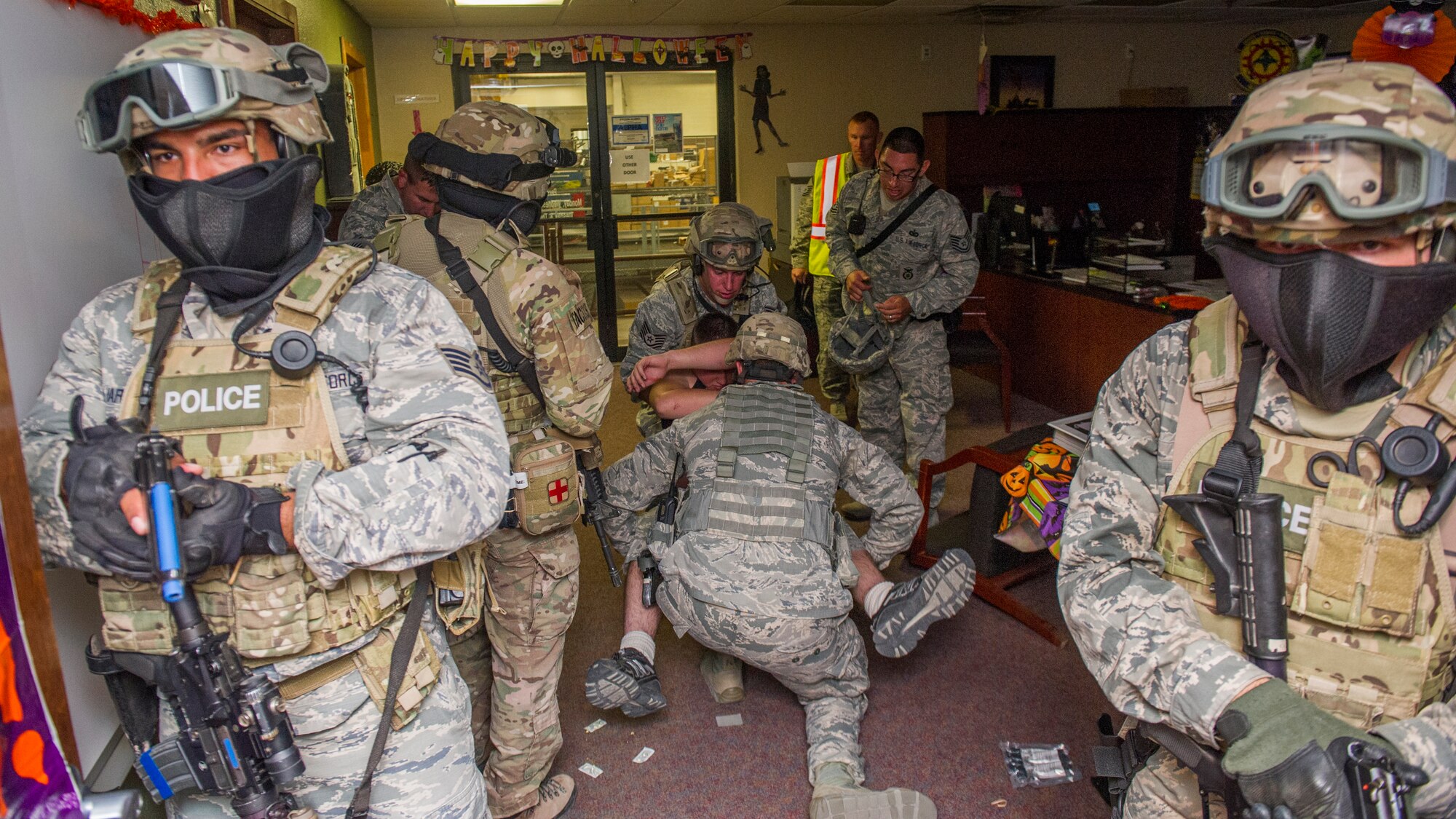 Members of the 49th Security Forces Squadron stabilize and extract a victim participant from an active shooter exercise at Holloman Air Force Base, N.M., Oct. 9. Holloman maintains readiness to respond to emergencies such as active shooters by conducting training exercises multiple times a year. Members from the 49th Security Forces Squadron, 49th Civil Engineer Squadron and the 49th Medical Group were able to quickly respond to the exercise scenario, neutralize the threats and evacuate the victims. (U.S. Air Force photo by Airman 1st Class Aaron Montoya / Released)