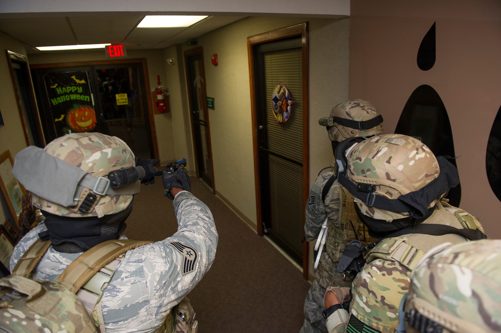 Members of the 49th Security Forces Squadron locate and close in on a hostile during an active shooter exercise at Holloman Air Force Base, N.M., Oct. 9. Holloman maintains readiness to respond to emergencies such as active shooters by conducting training exercises multiple times a year. Members from the 49th Security Forces Squadron, 49th Civil Engineer Squadron and the 49th Medical Group were able to quickly respond to the exercise scenario, neutralize the threats and evacuate the victims. (U.S. Air Force photo by Airman 1st Class Aaron Montoya / Released)