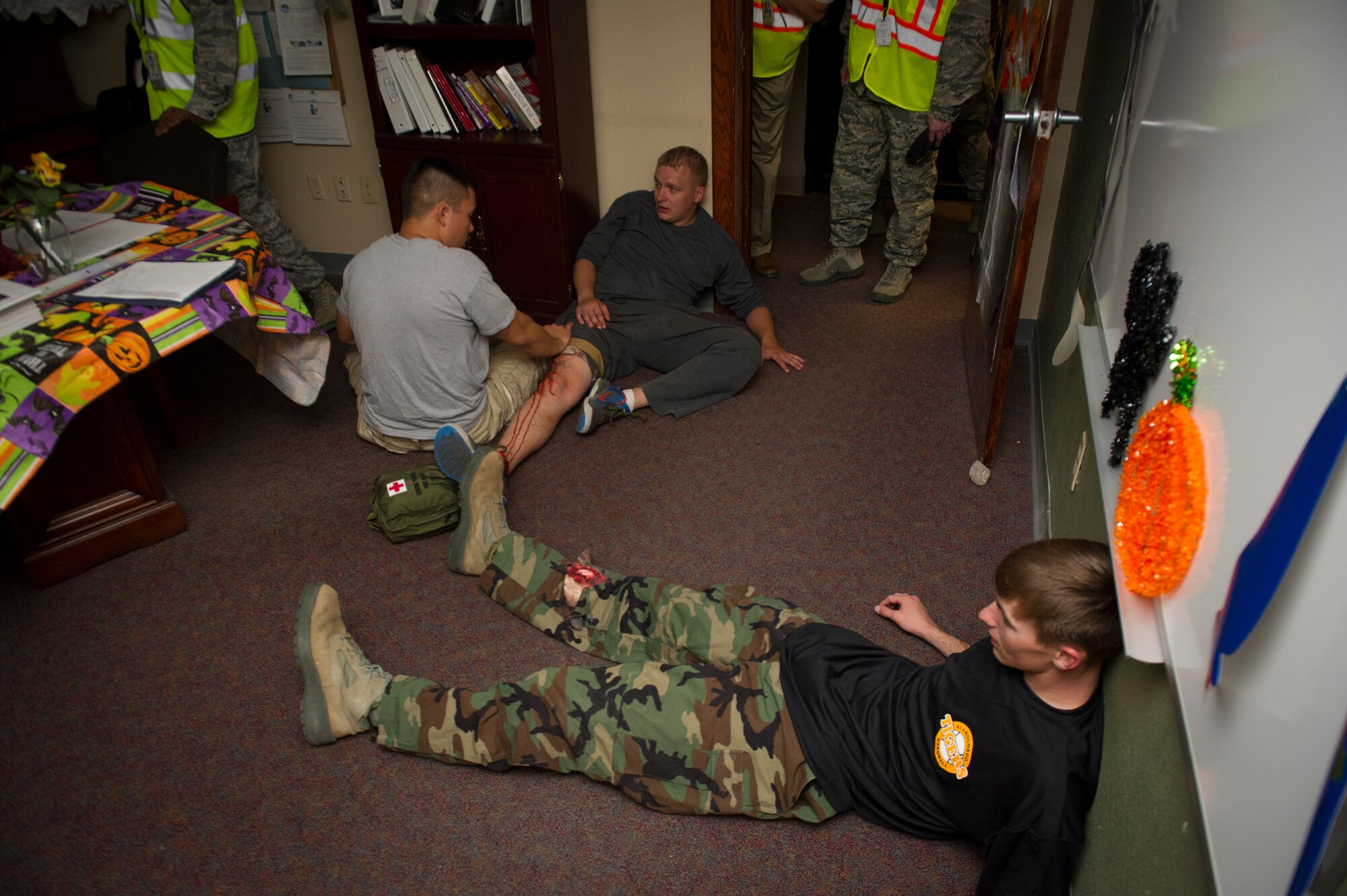 Victim participants hide from hostiles and attend to each other’s simulated wounds while waiting for medical assistance during an active shooter exercise at Holloman Air Force Base, N.M., Oct. 9. Holloman maintains readiness to respond to emergencies such as active shooters by conducting training exercises multiple times a year. Members from the 49th Security Forces Squadron, 49th Civil Engineer Squadron and the 49th Medical Group were able to quickly respond to the exercise scenario, neutralize the threats and evacuate the victims. (U.S. Air Force photo by Airman 1st Class Aaron Montoya / Released)