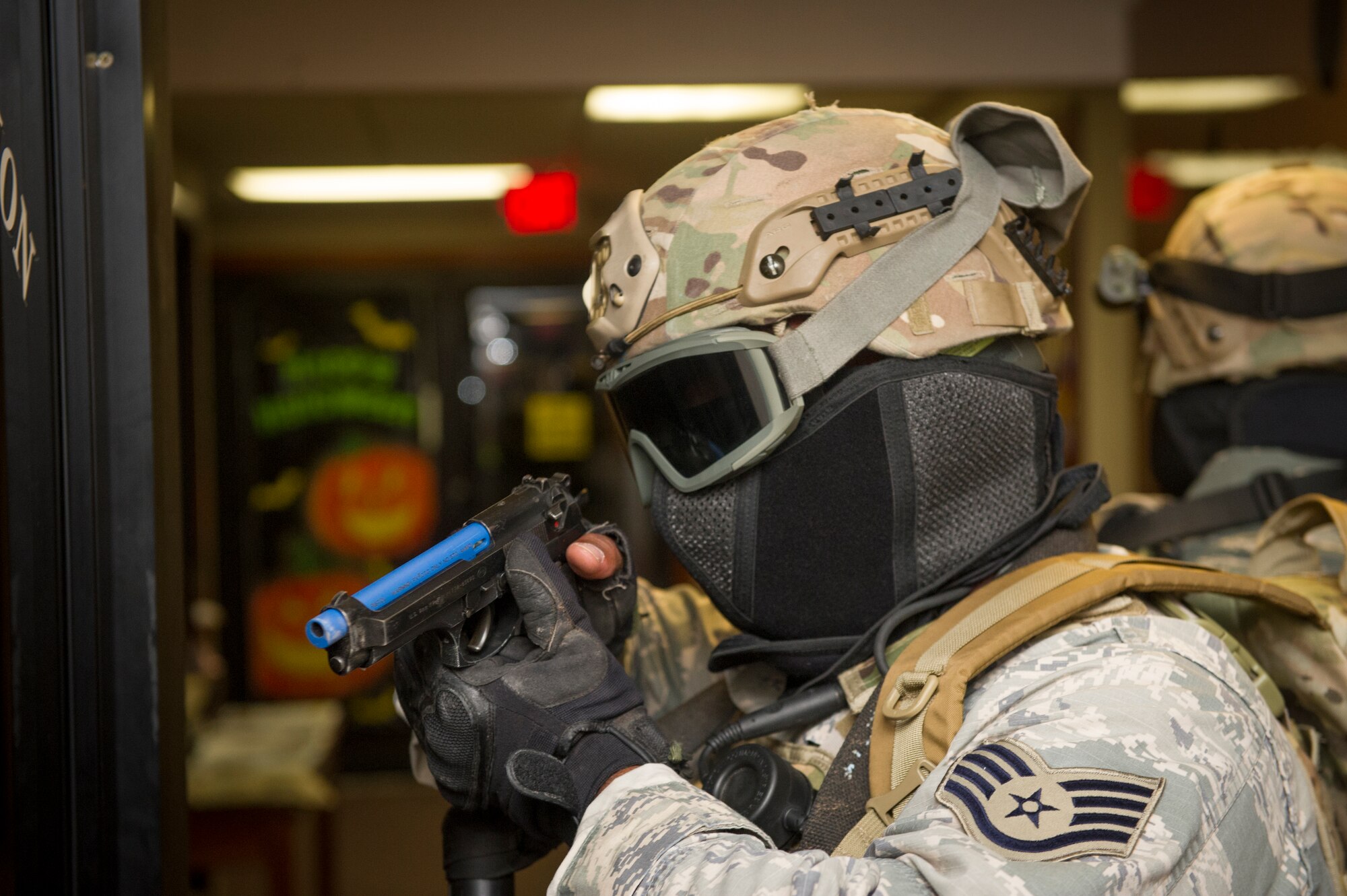 A 49th Security Forces Squadron member looks out for fellow SFS members as they check and clear rooms while looking for hostile during an active shooter exercise at Holloman Air Force Base, N.M., Oct. 9. Holloman maintains readiness to respond to emergencies such as active shooters by conducting training exercises multiple times a year. Members from the 49th Security Forces Squadron, 49th Civil Engineer Squadron and the 49th Medical Group were able to quickly respond to the exercise scenario, neutralize the threats and evacuate the victims. (U.S. Air Force photo by Airman 1st Class Aaron Montoya / Released)