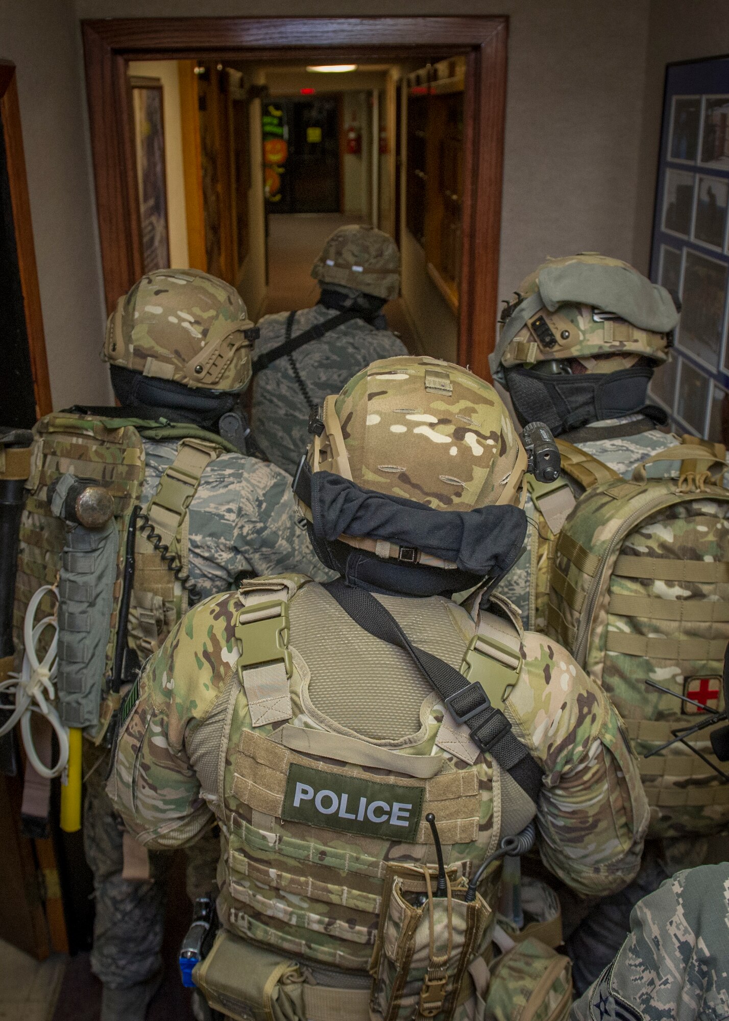 Members of the 49th Security Forces Squadron attempt to neutralize the situation by clearing rooms and checking for hostiles during an active shooter exercise at Holloman Air Force Base, N.M., Oct. 9. Holloman maintains readiness to respond to emergencies such as active shooters by conducting training exercises multiple times a year. Members from the 49th Security Forces Squadron, 49th Civil Engineer Squadron and the 49th Medical Group were able to quickly respond to the exercise scenario, neutralize the threats and evacuate the victims. (U.S. Air Force photo by Airman 1st Class Aaron Montoya / Released)