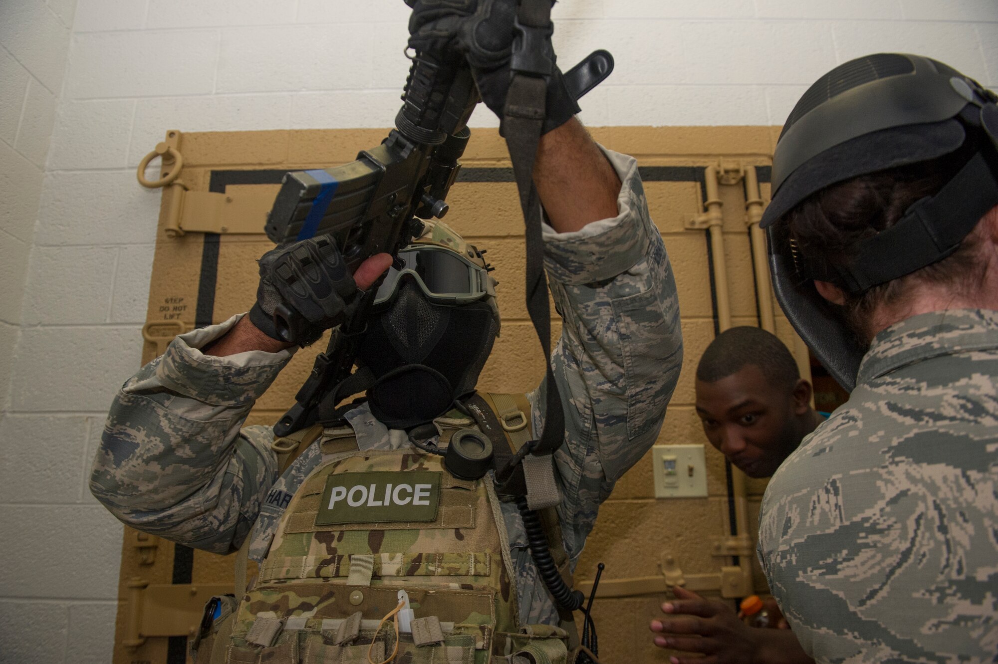 A member of the 49th Security Forces Squadron surveillances for hostiles in a stairwell as victim participants are extracted from the danger zone during an active shooter exercise at Holloman Air Force Base, N.M., Oct. 9. Holloman maintains readiness to respond to emergencies such as active shooters by conducting training exercises multiple times a year. Members from the 49th Security Forces Squadron, 49th Civil Engineer Squadron and the 49th Medical Group were able to quickly respond to the exercise scenario, neutralize the threats and evacuate the victims. (U.S. Air Force photo by Airman 1st Class Aaron Montoya / Released)