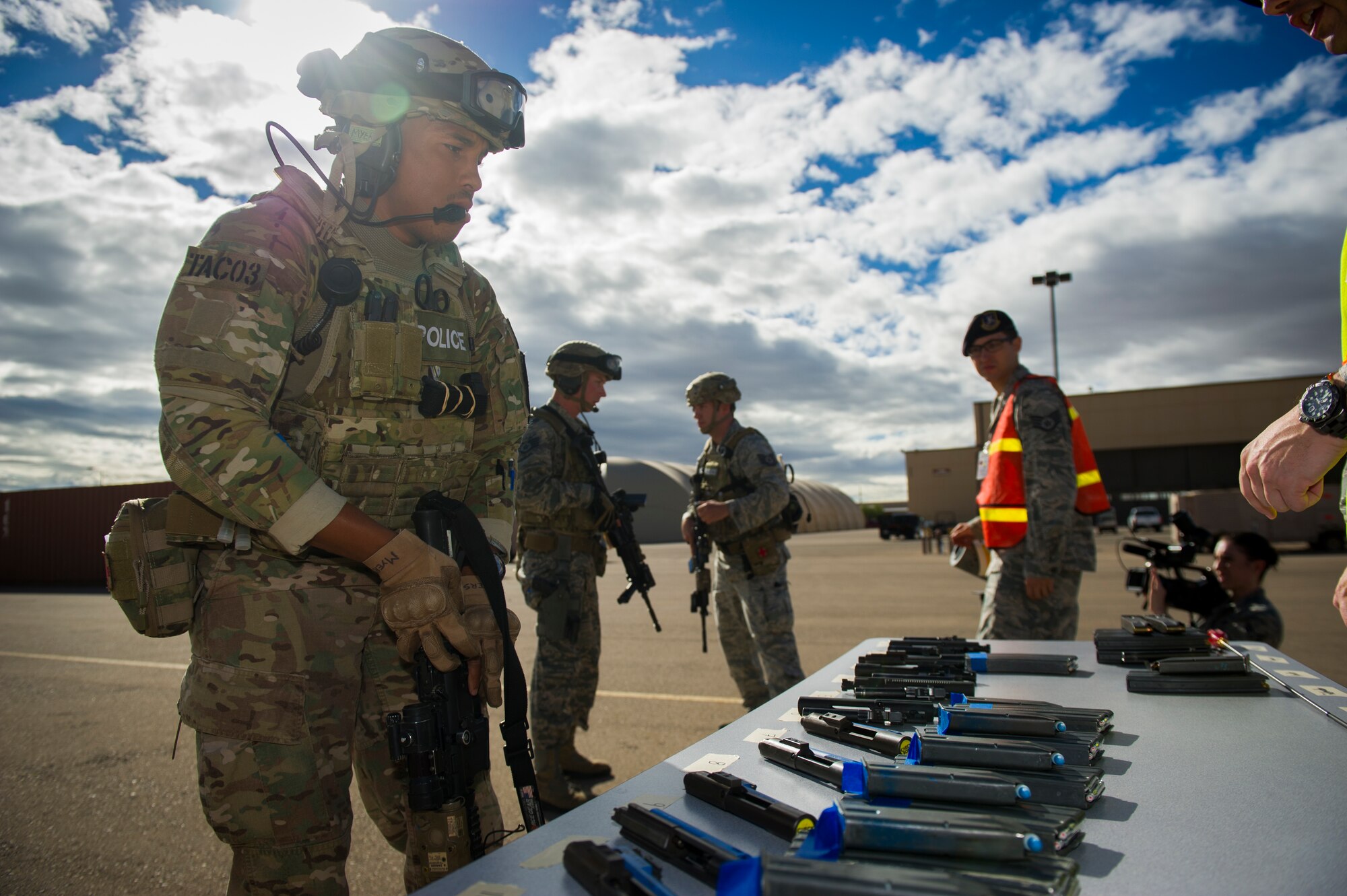Members of the 49th Security Forces Squadron clear and arm their weapons before participating in an active shooter exercise at Holloman Air Force Base, N.M., Oct. 9. Holloman maintains readiness to respond to emergencies such as active shooters by conducting training exercises multiple times a year. Members from the 49th Security Forces Squadron, 49th Civil Engineer Squadron and the 49th Medical Group were able to quickly respond to the exercise scenario, neutralize the threats and evacuate the victims. (U.S. Air Force photo by Airman 1st Class Aaron Montoya / Released)