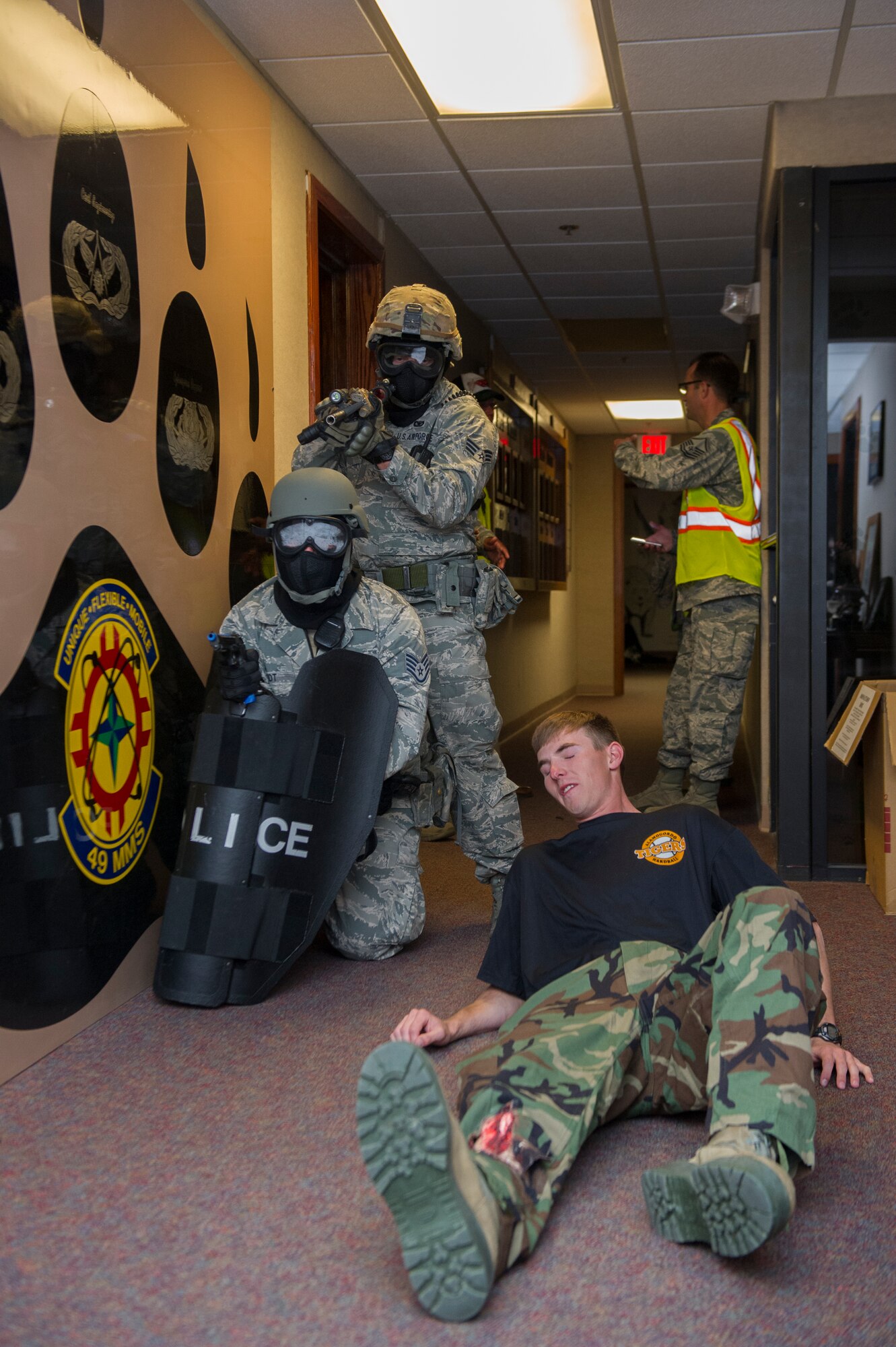Members of the 49th Security Forces Squadron protect a victim participant as he is extracted from a dangerous area during an active shooter exercise at Holloman Air Force Base, N.M., Oct. 9. Holloman maintains readiness to respond to emergencies such as active shooters by conducting training exercises multiple times a year. Members from the 49th Security Forces Squadron, 49th Civil Engineer Squadron and the 49th Medical Group were able to quickly respond to the exercise scenario, neutralize the threats and evacuate the victims. (U.S. Air Force photo by Airman 1st Class Aaron Montoya / Released)