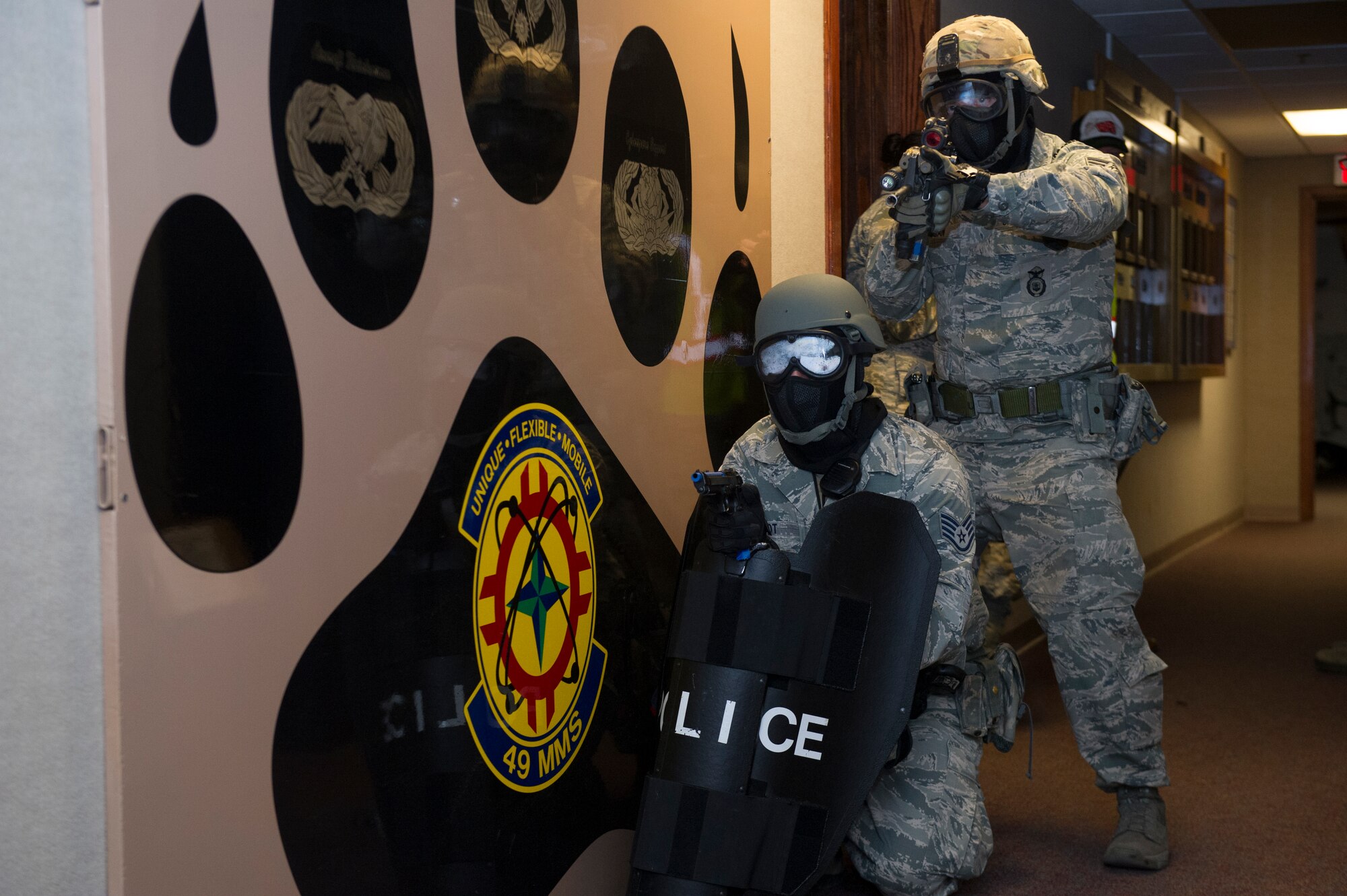 Members of the 49th Security Forces Squadron clear rooms while checking for hostiles during an active shooter exercise at Holloman Air Force Base, N.M., Oct. 9. Holloman maintains readiness to respond to emergencies such as active shooters by conducting training exercises multiple times a year. Members from the 49th Security Forces Squadron, 49th Civil Engineer Squadron and the 49th Medical Group were able to quickly respond to the exercise scenario, neutralize the threats and evacuate the victims. (U.S. Air Force photo by Airman 1st Class Aaron Montoya / Released)